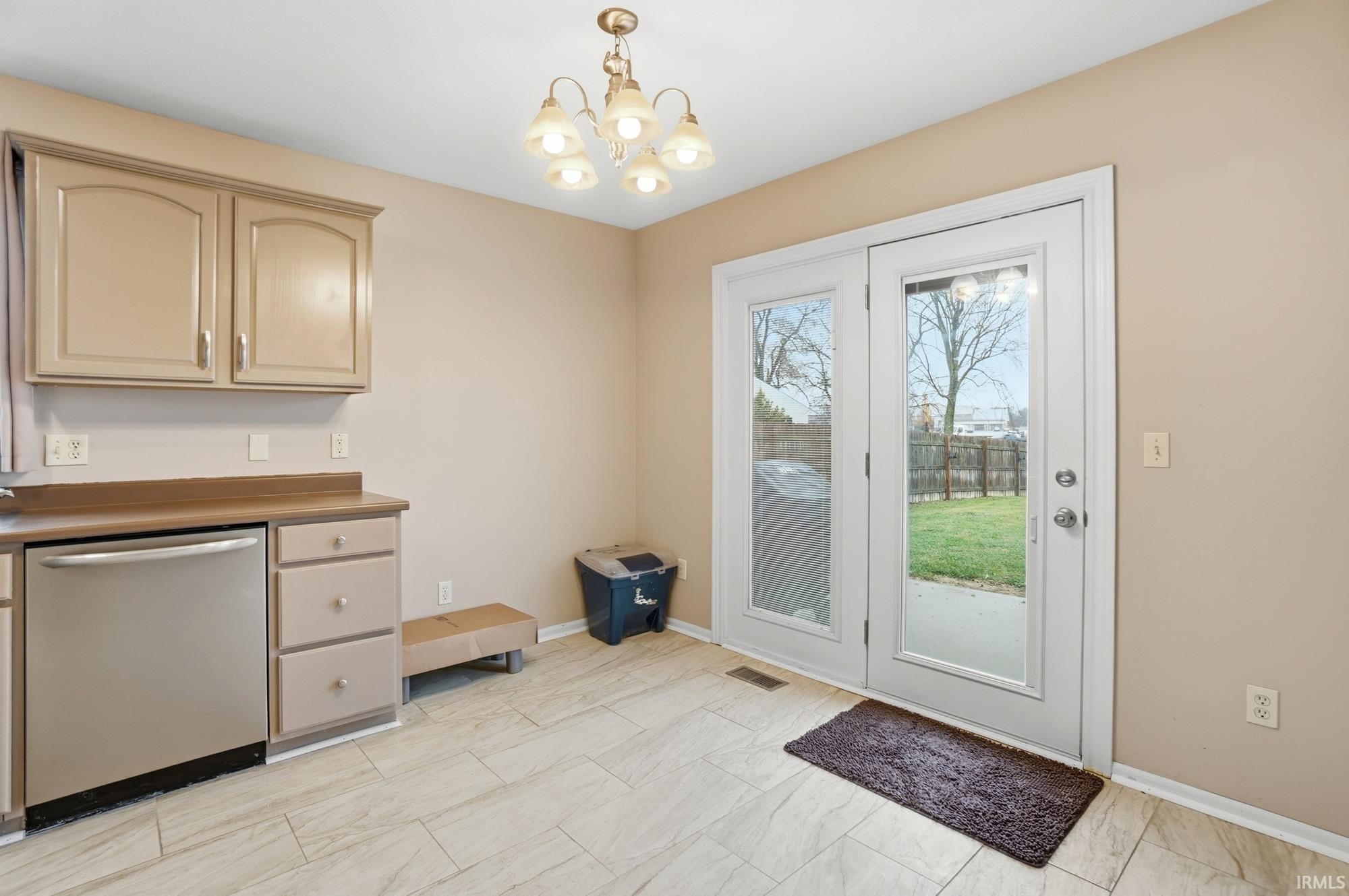 Doorway to outside with a chandelier and baseboards