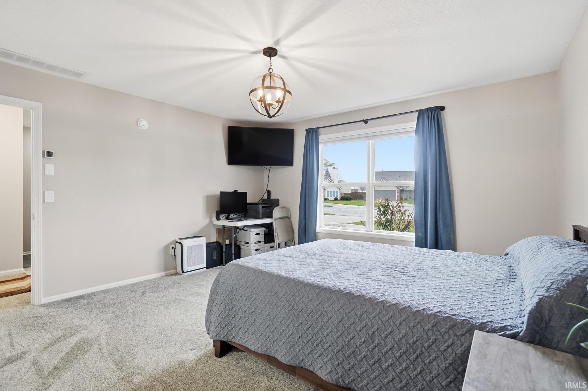 Bedroom with carpet and a chandelier