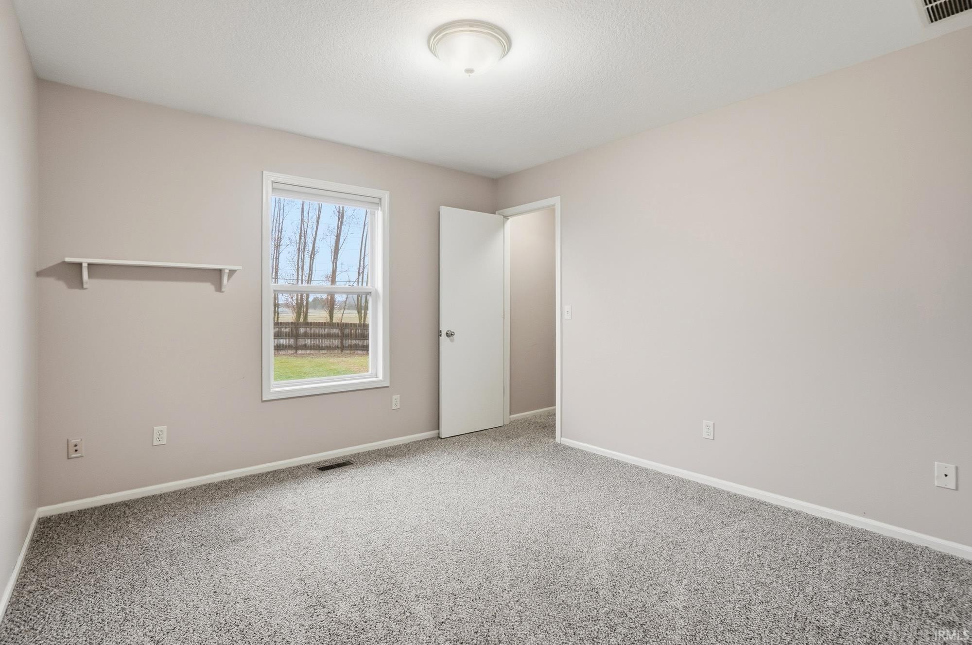 Empty room with carpet floors and baseboards
