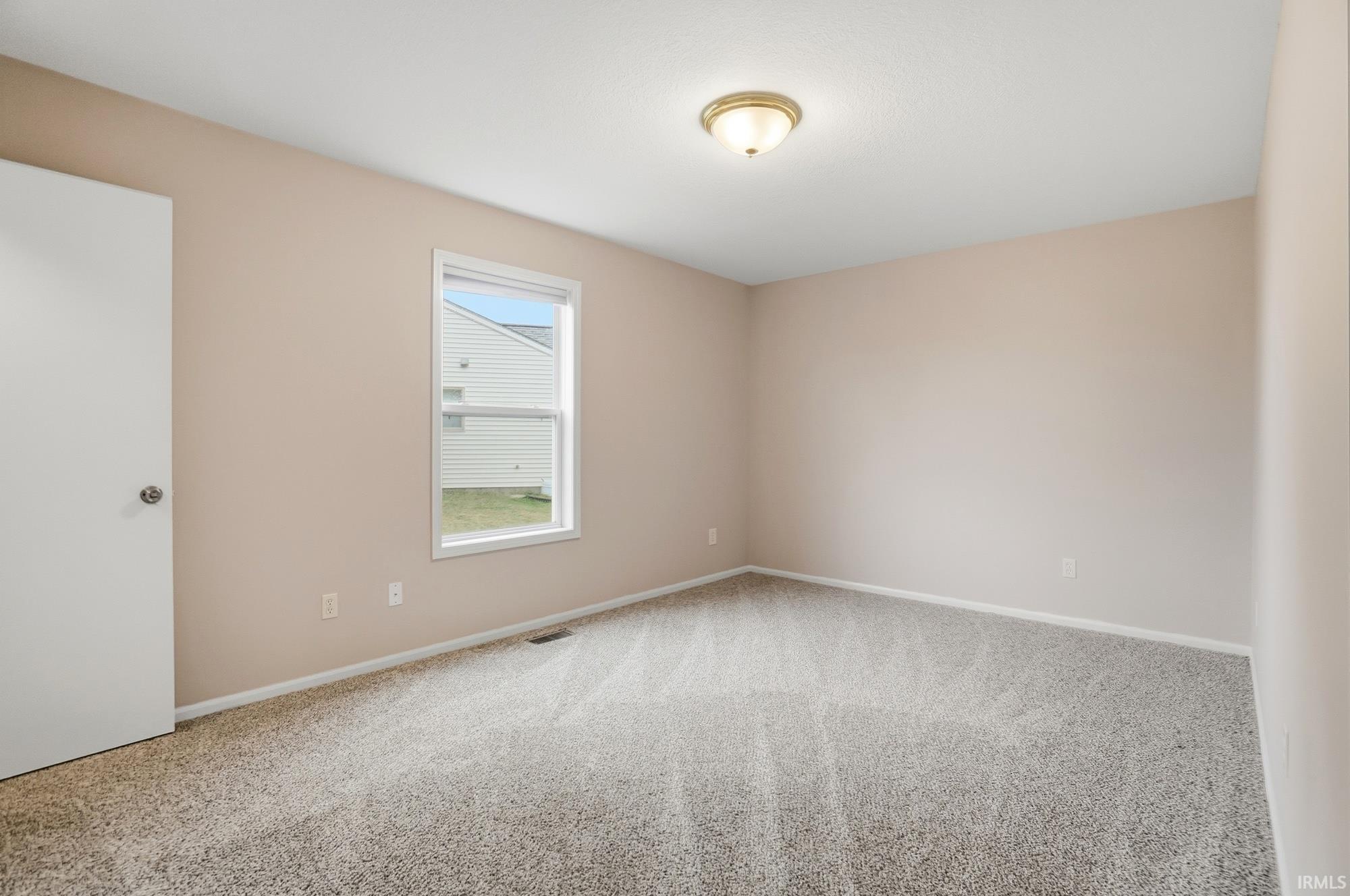 Carpeted empty room with baseboards