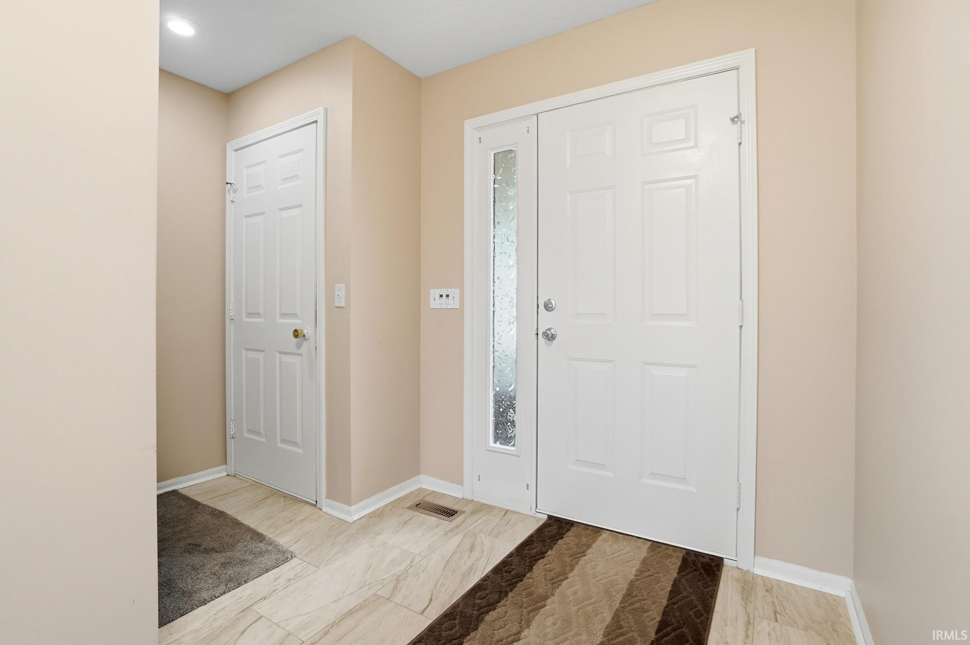 Entrance foyer featuring light marble finish flooring and baseboards