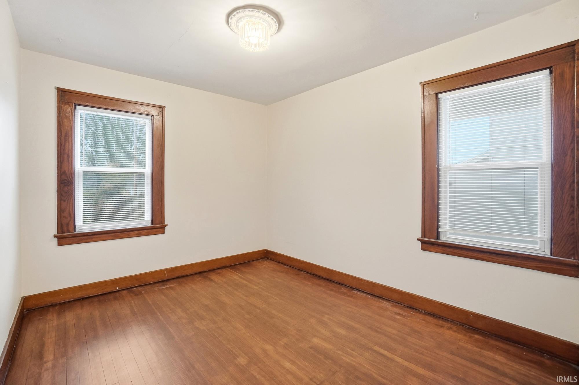 Unfurnished room featuring baseboards and hardwood / wood-style floors