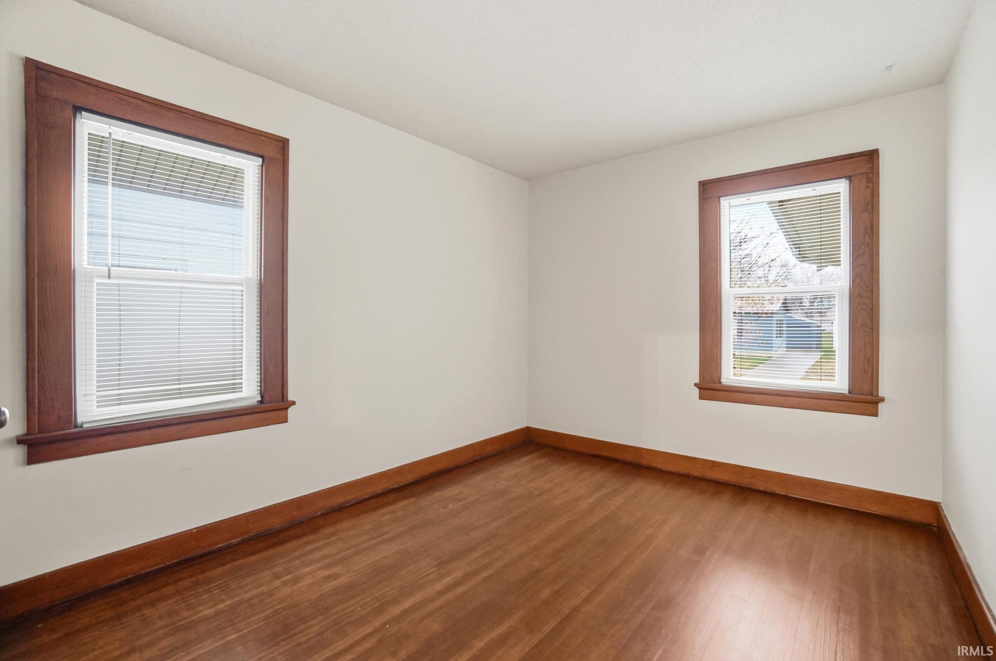 Unfurnished room with hardwood / wood-style flooring and baseboards