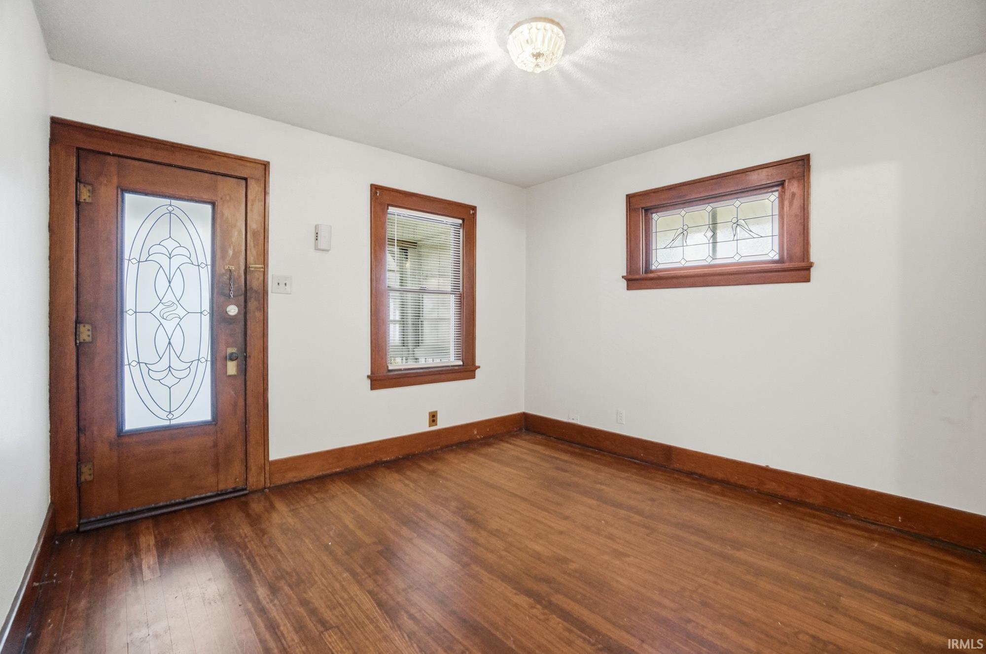 Entrance foyer featuring baseboards and dark wood-type flooring