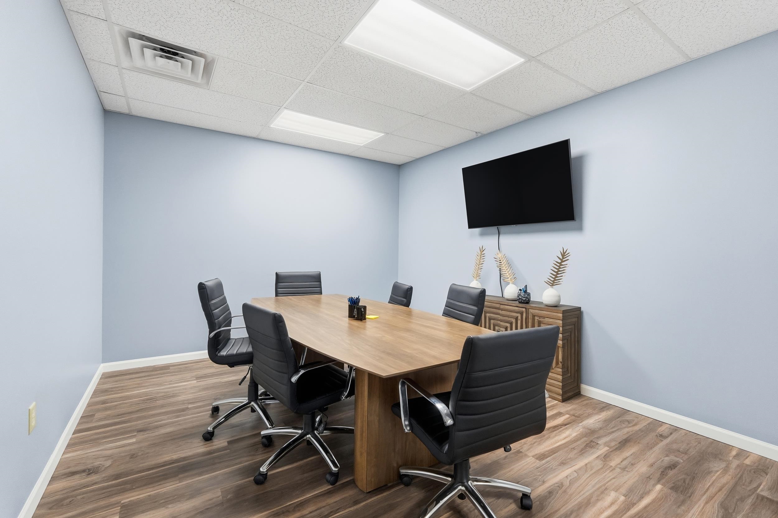 Office space with wood finished floors and a drop ceiling