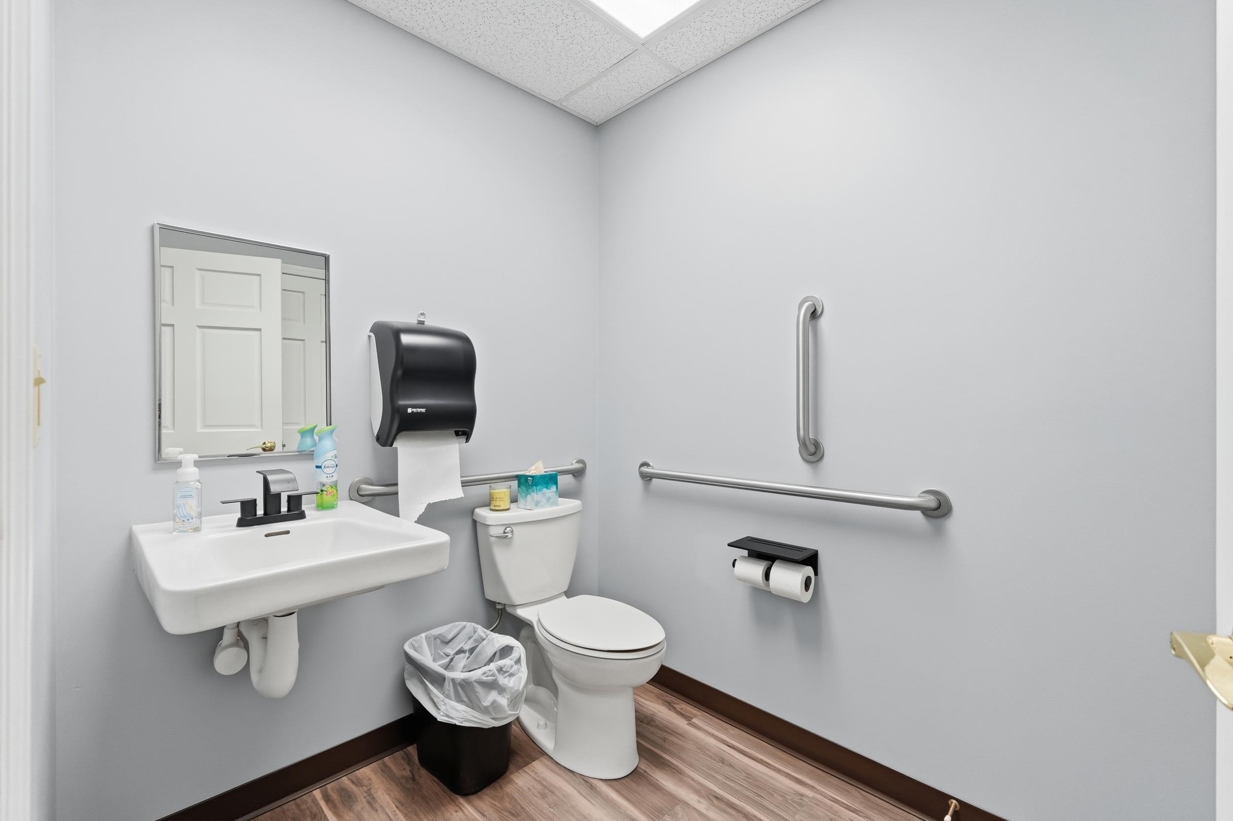 Half bathroom with a drop ceiling and light wood-type flooring