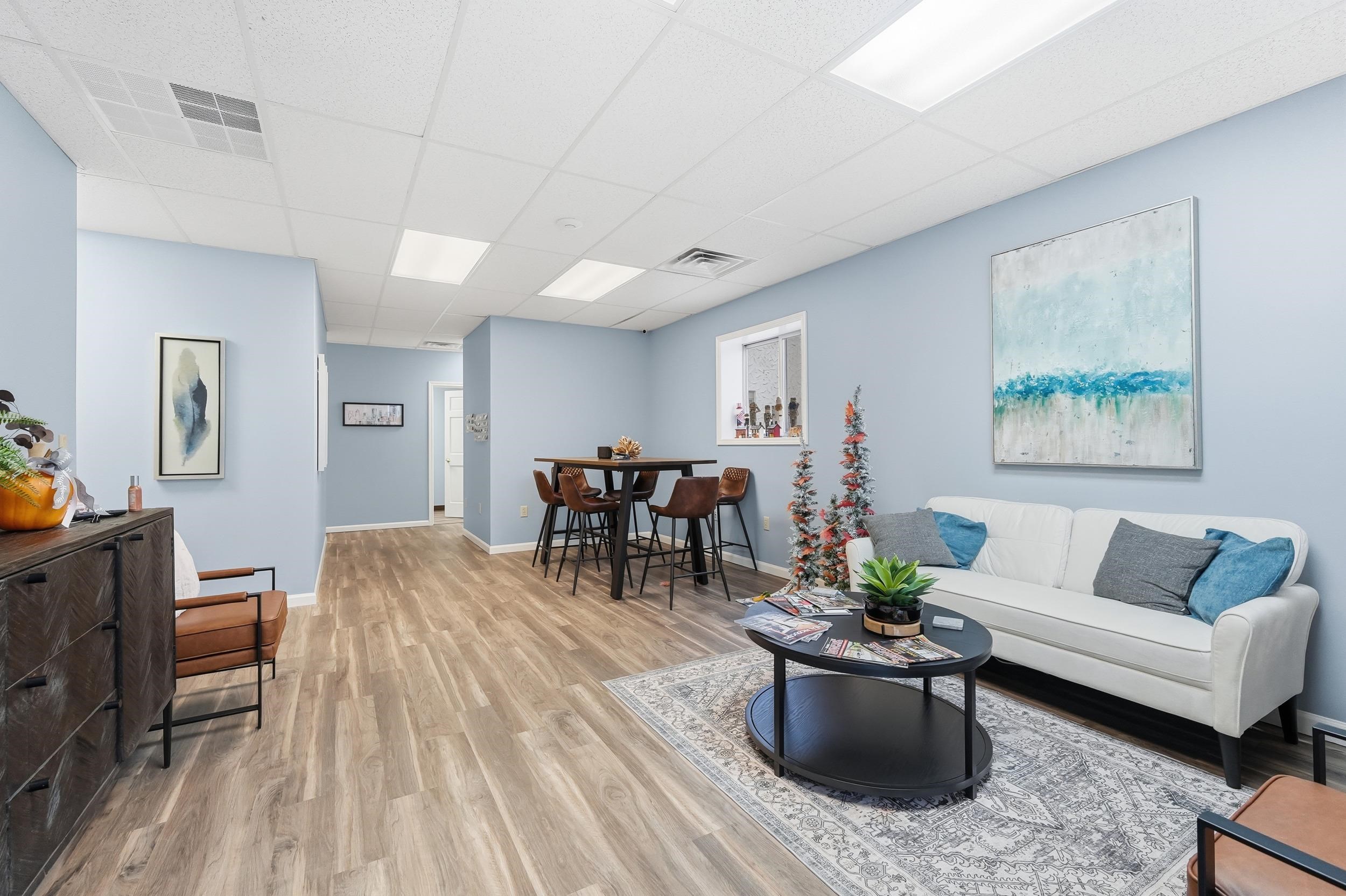 Living room with a drop ceiling and light wood-style flooring