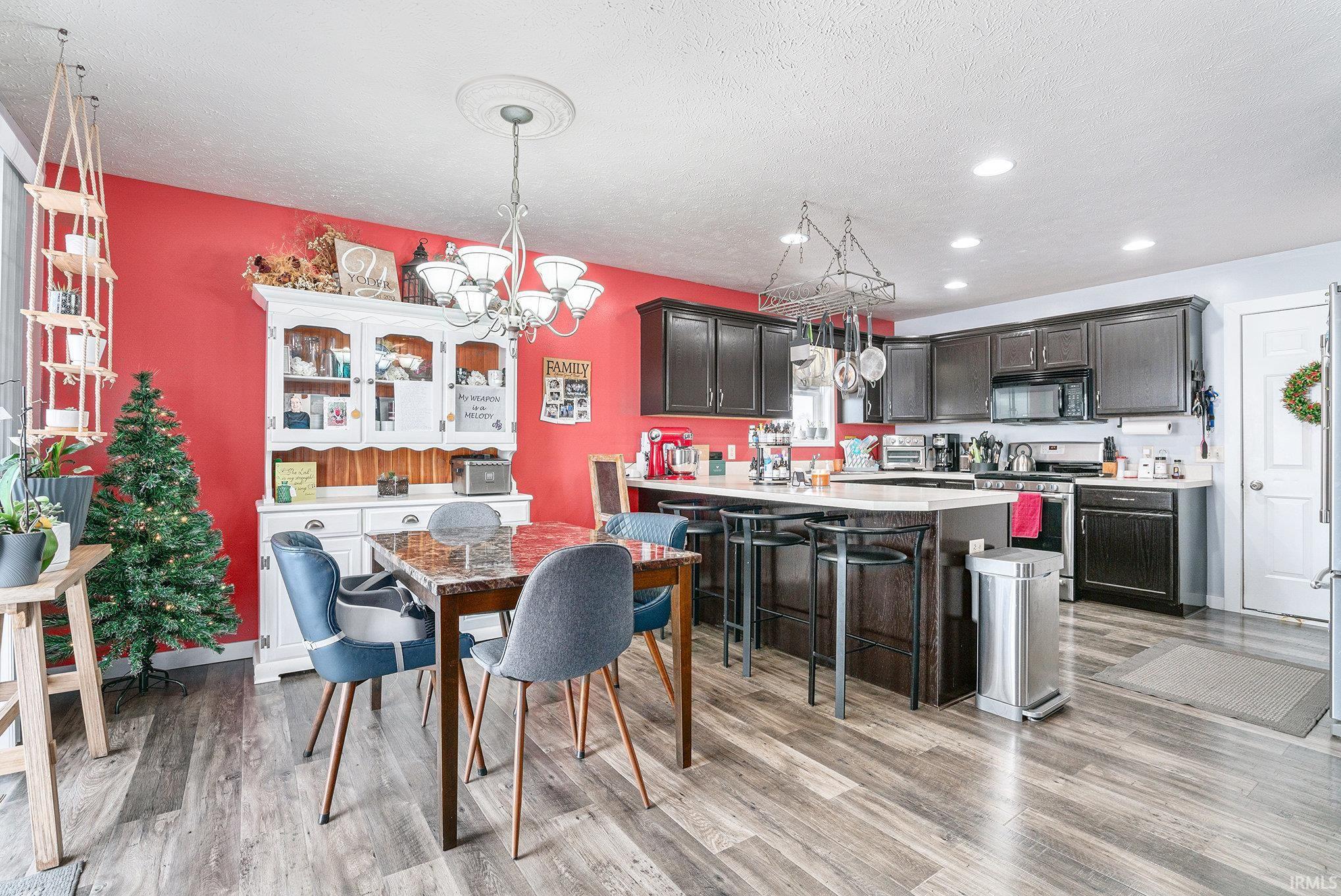Dining area with light wood-style floors, recessed lighting, a textured ceiling, and a chandelier