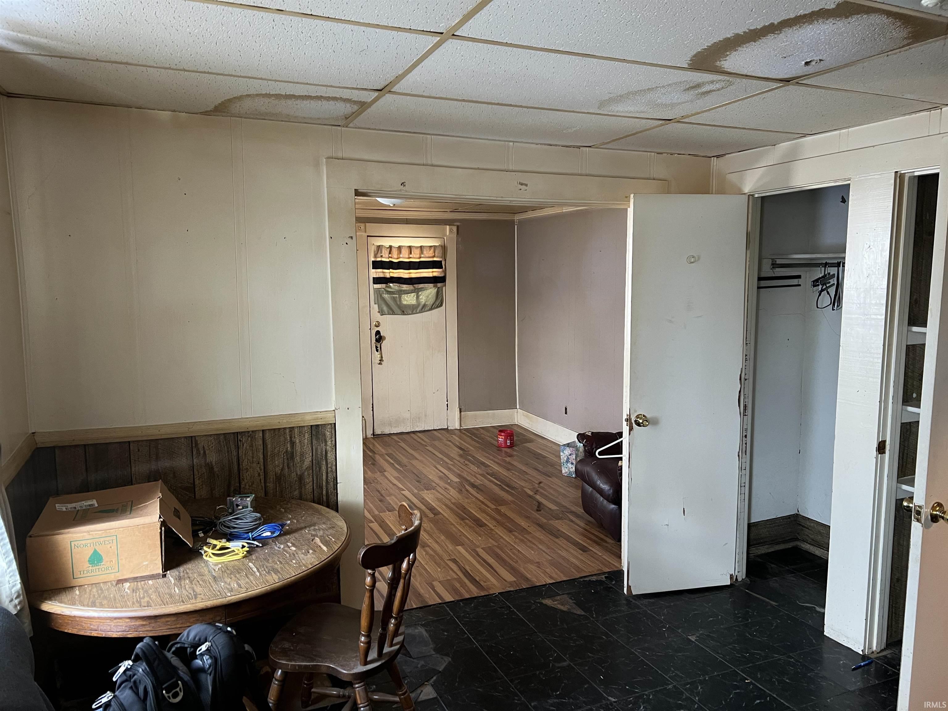 Dining room with a paneled ceiling and dark wood-style floors