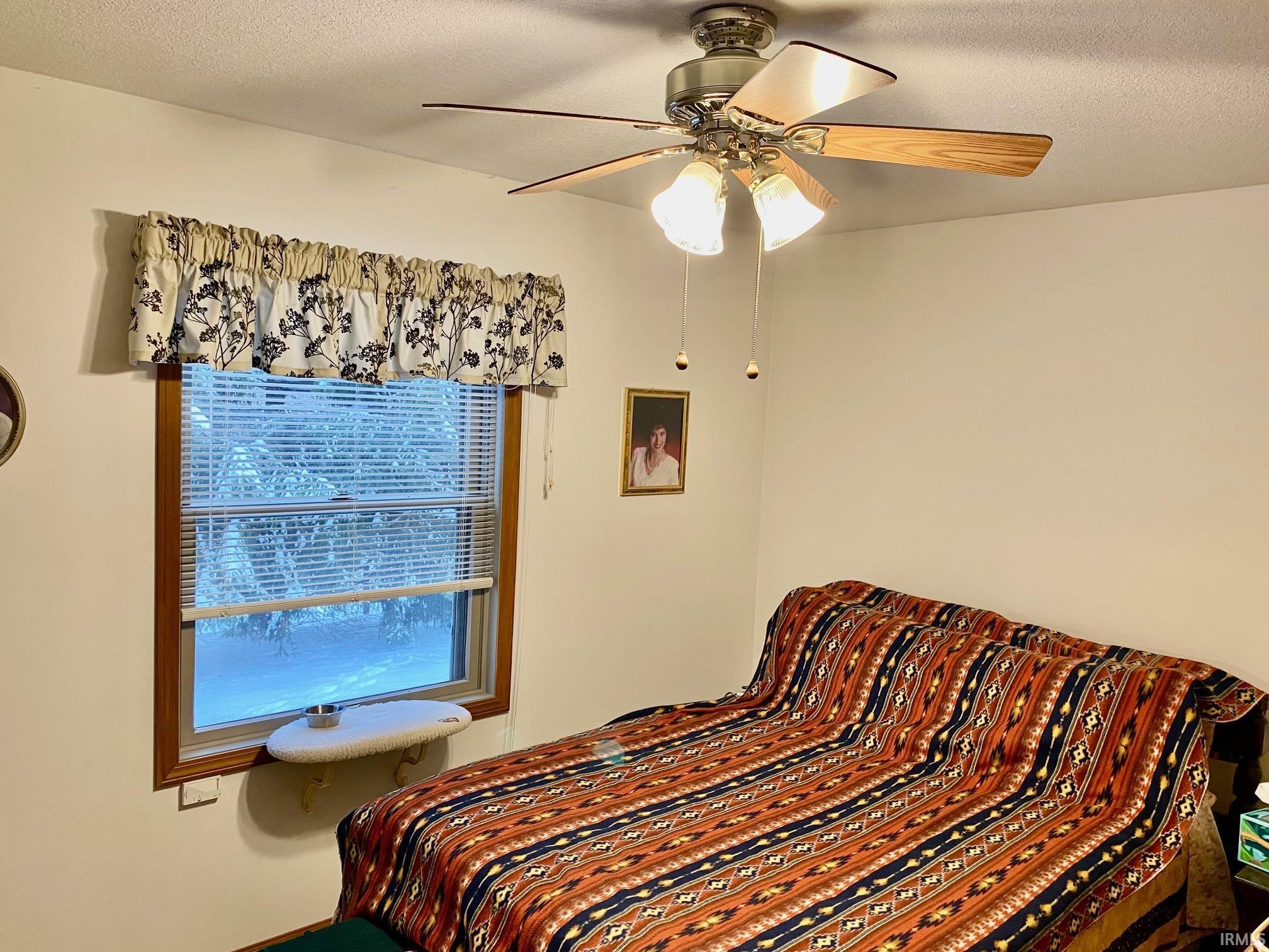 Bedroom featuring a textured ceiling and a ceiling fan
