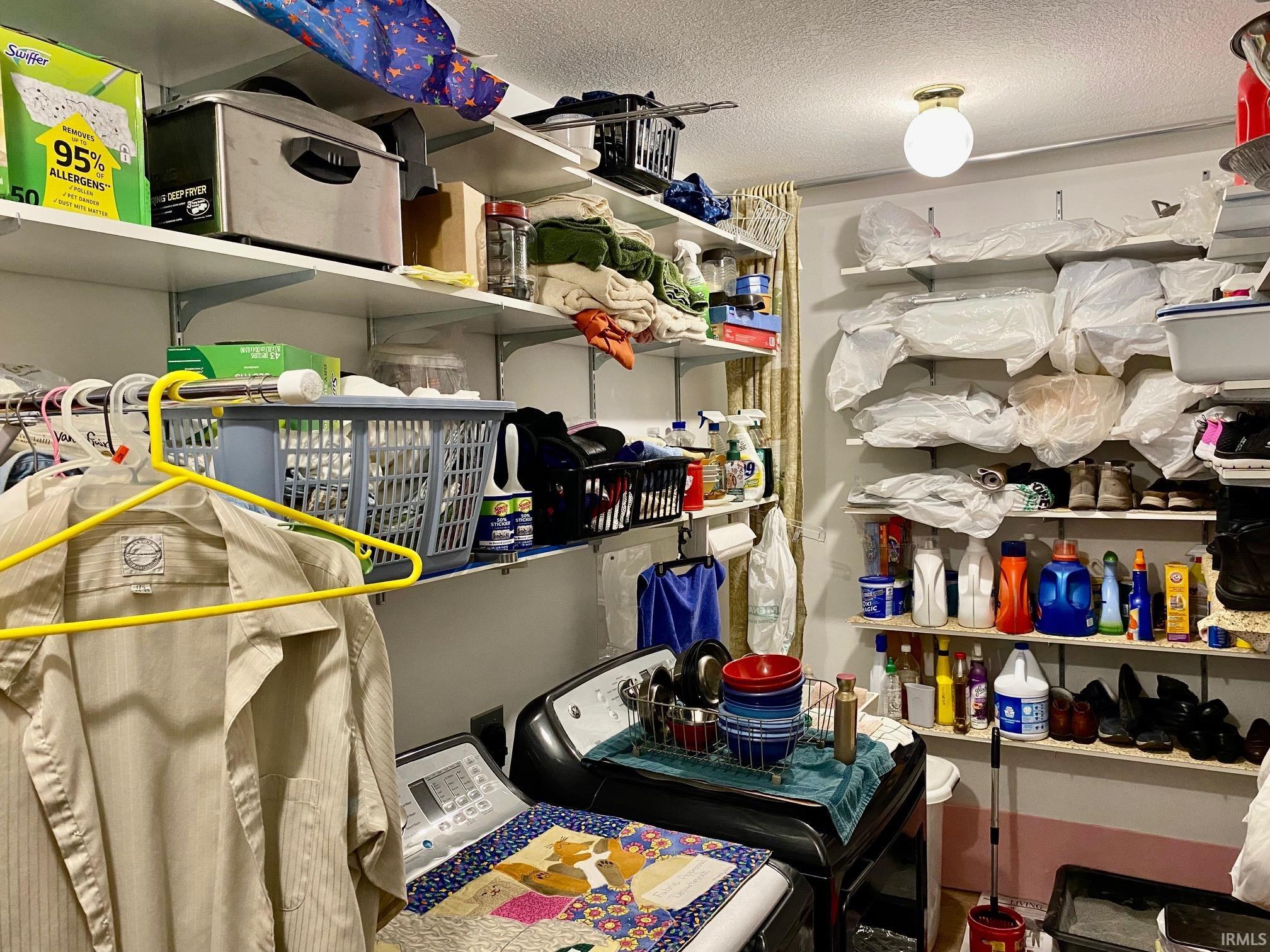 Storage room featuring washing machine and clothes dryer
