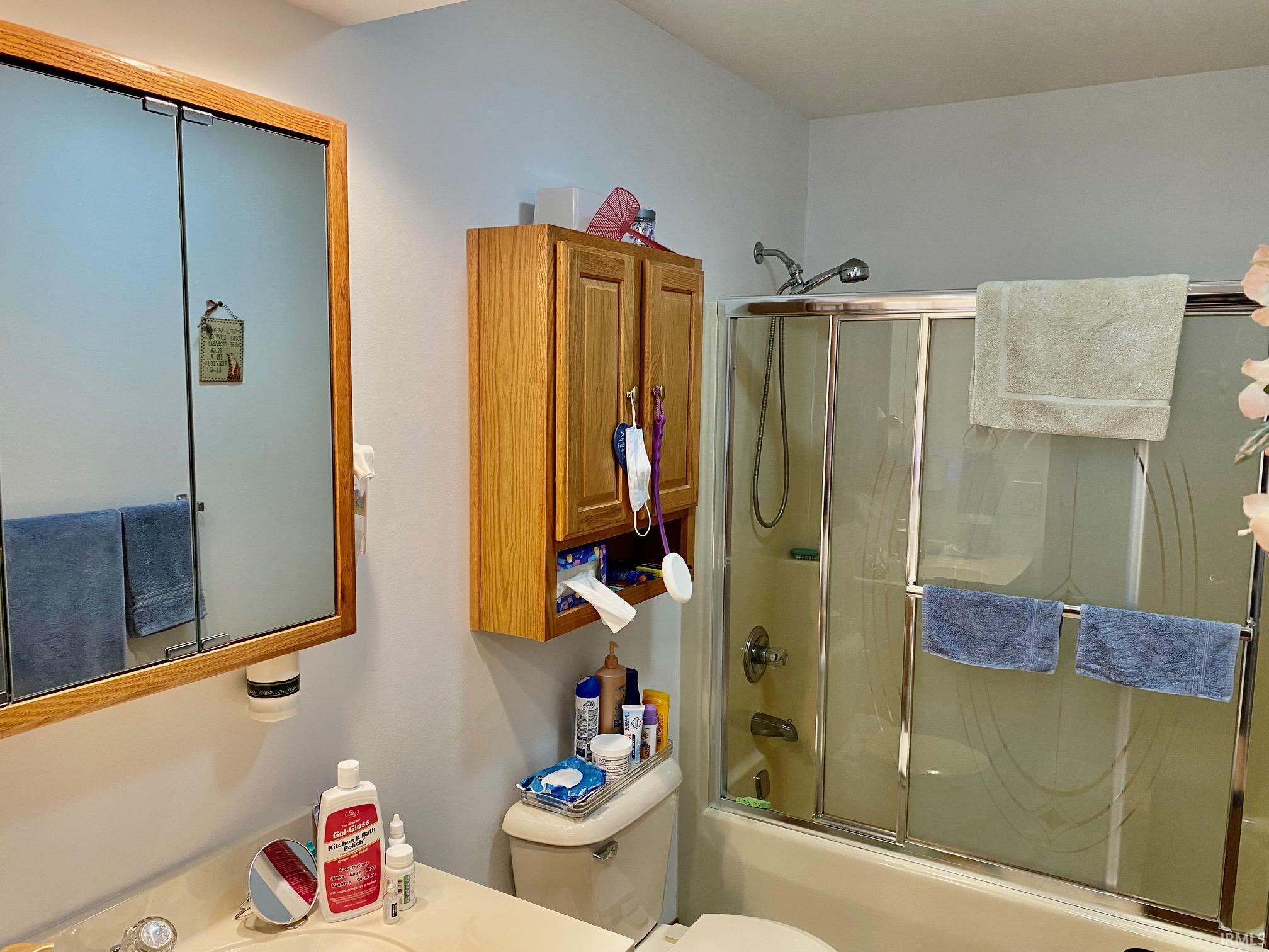 Bathroom featuring shower / bath combination with glass door and vanity