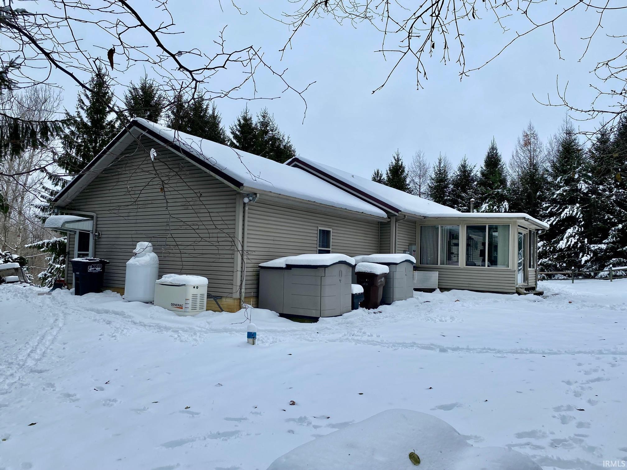 View of snow covered exterior featuring a sunroom