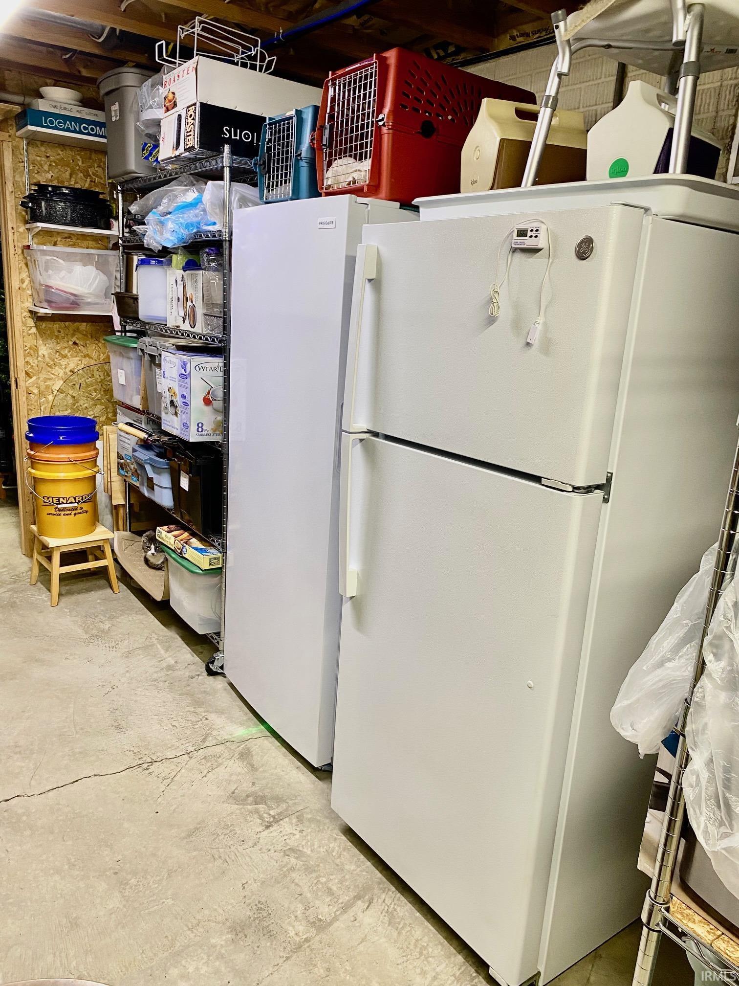Kitchen with freestanding refrigerator and concrete floors