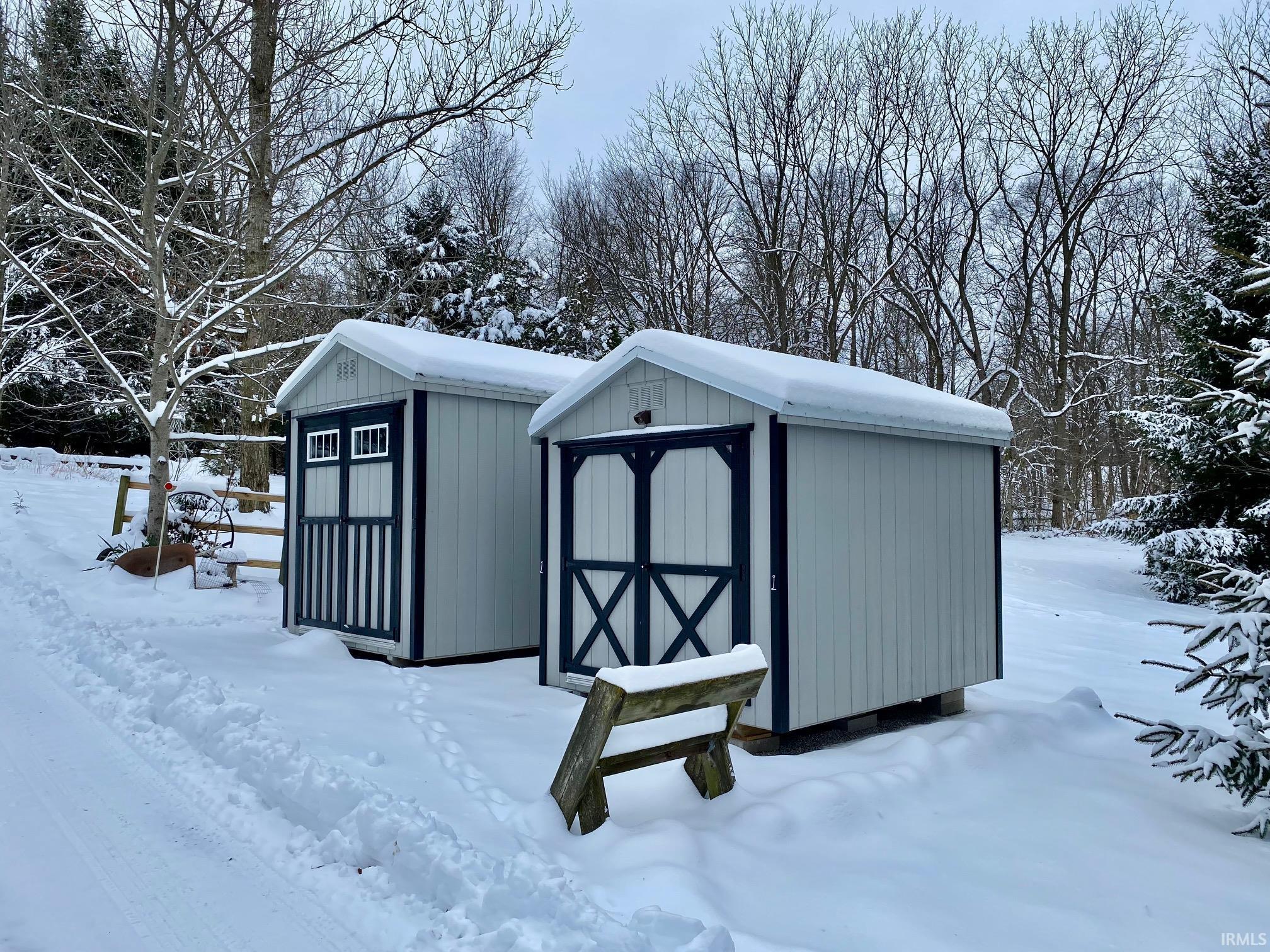Snow covered structure featuring a shed