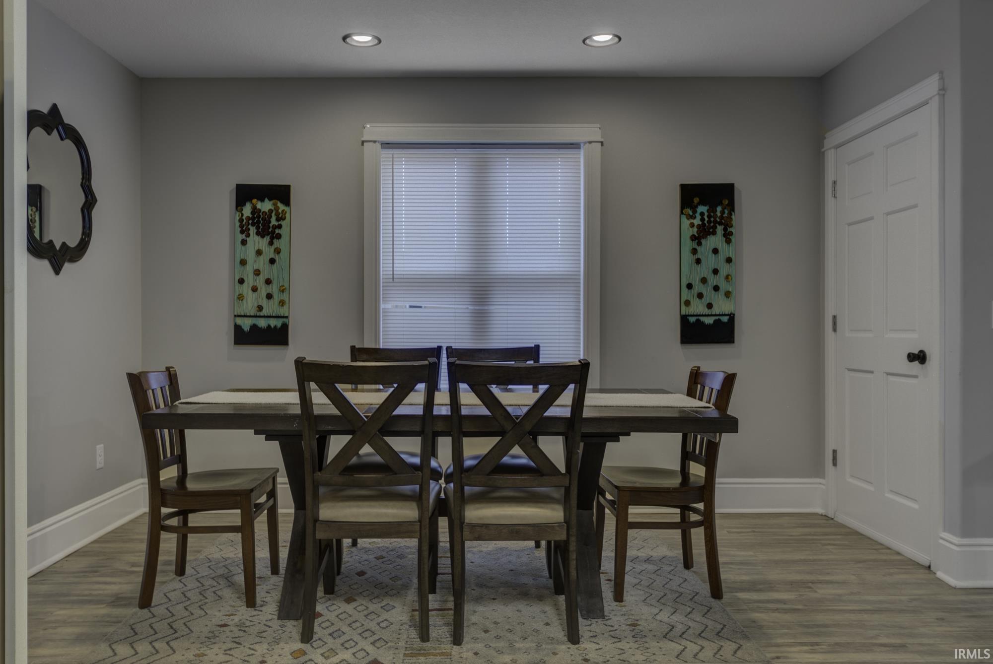 Dining area with light wood-style floors and recessed lighting