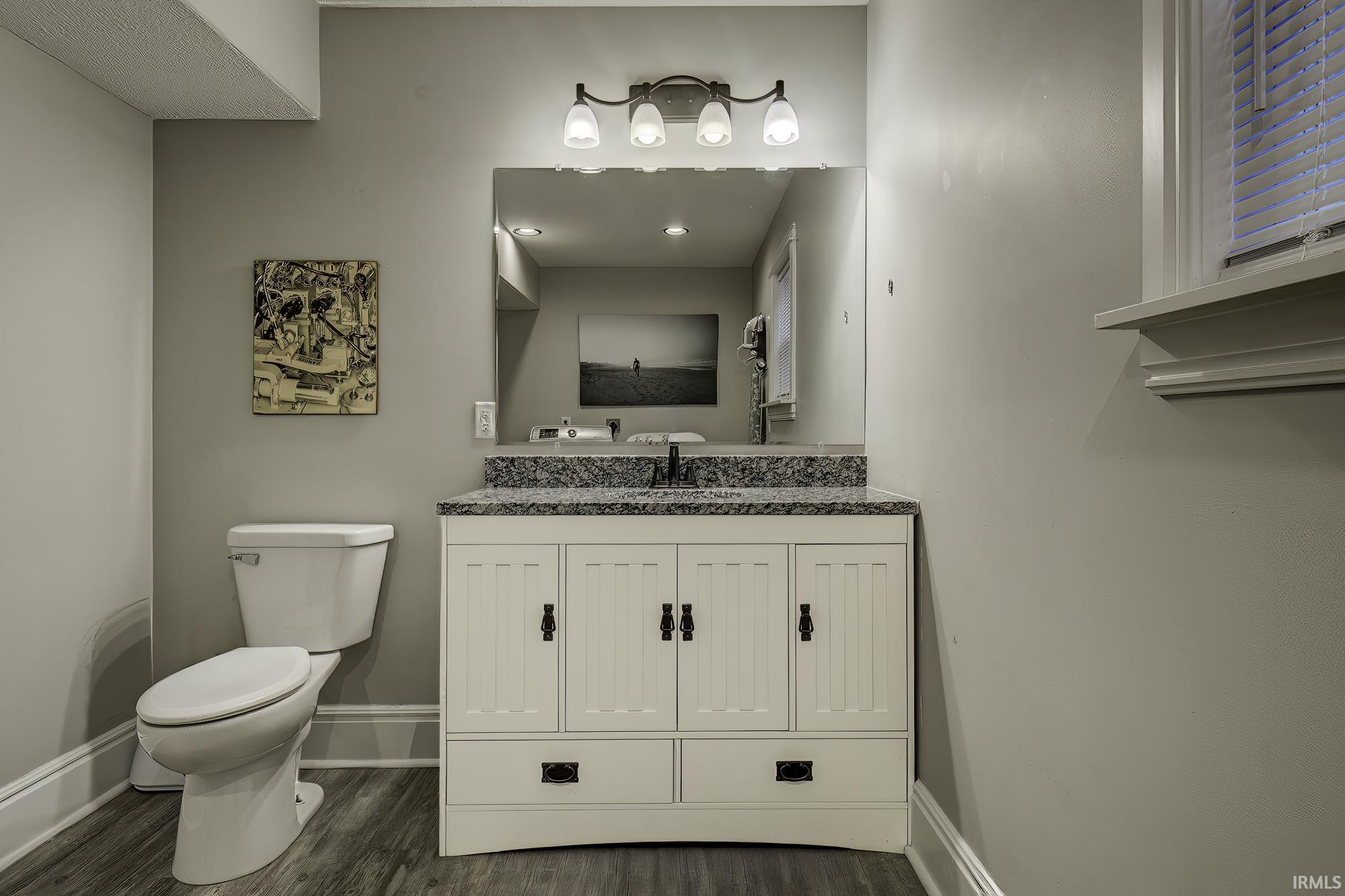 Half bathroom with vanity and dark wood finished floors