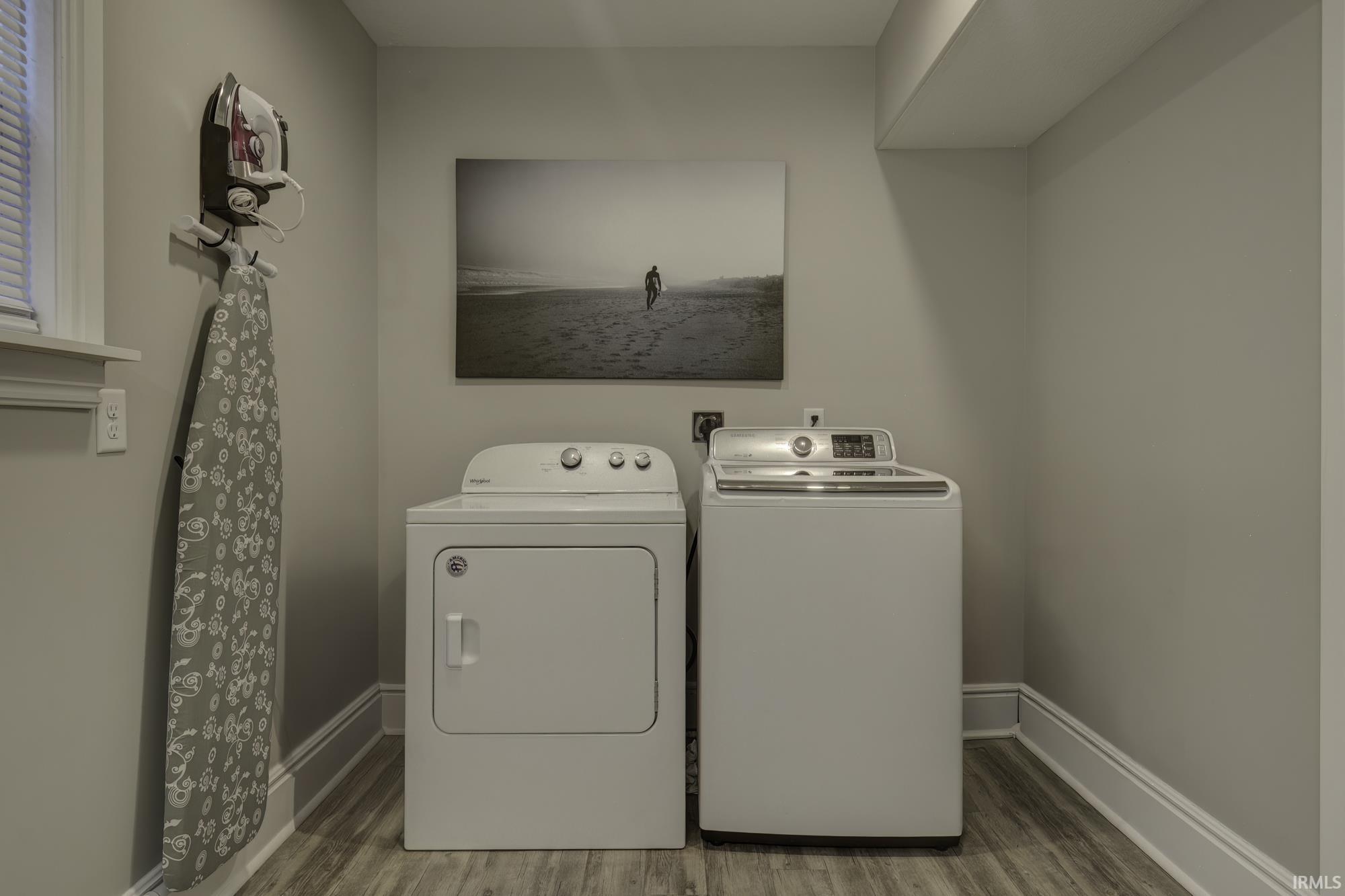 Laundry room featuring wood finished floors and independent washer and dryer