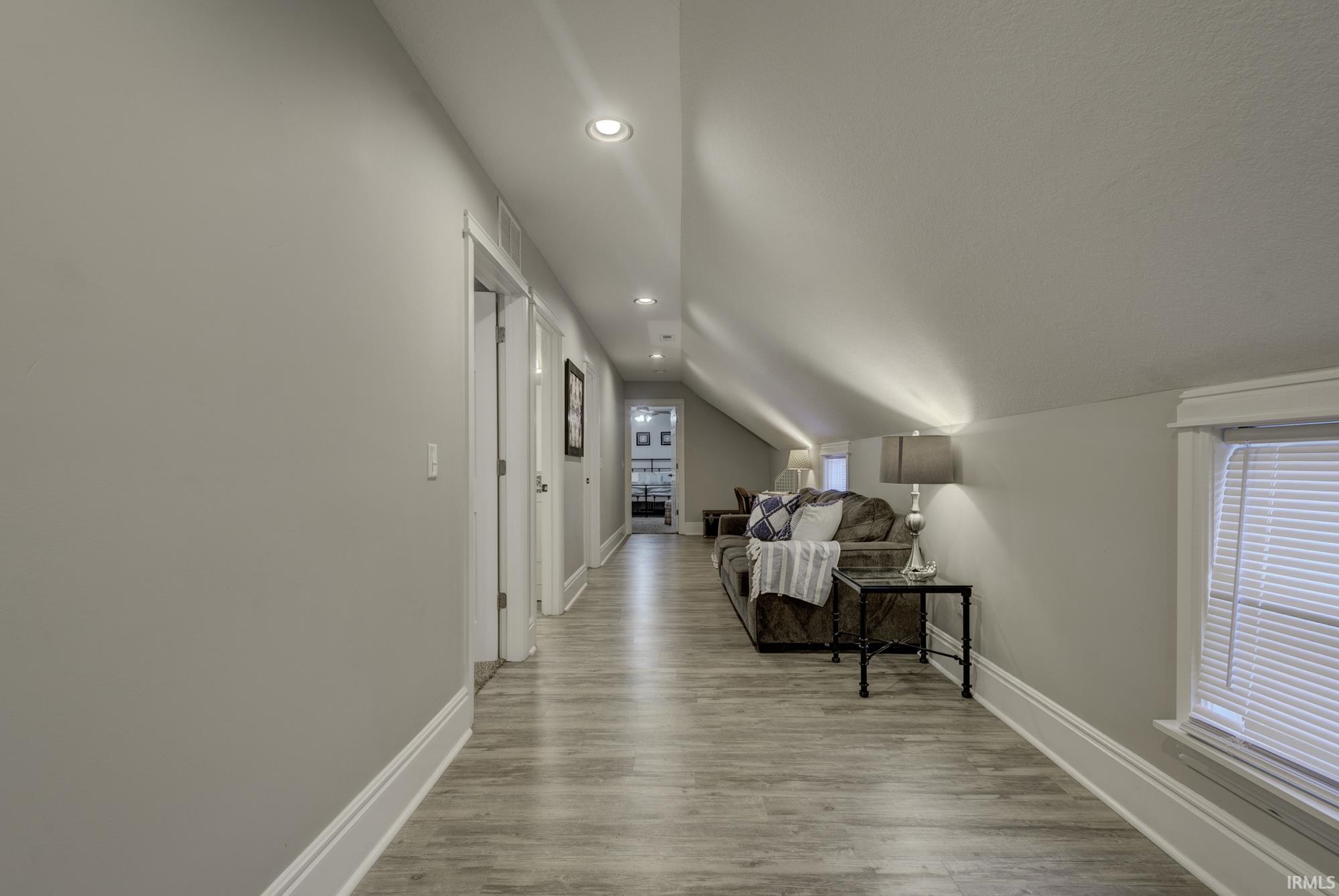 Corridor featuring recessed lighting, lofted ceiling, and light wood-style floors
