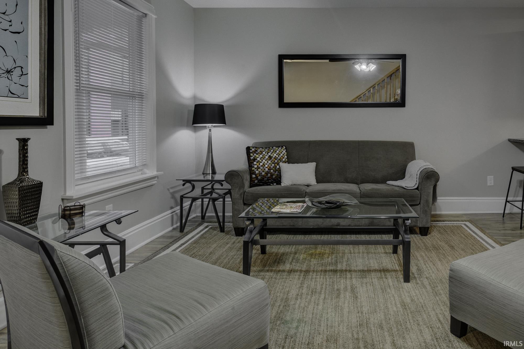 Living room with baseboards and light wood-style flooring