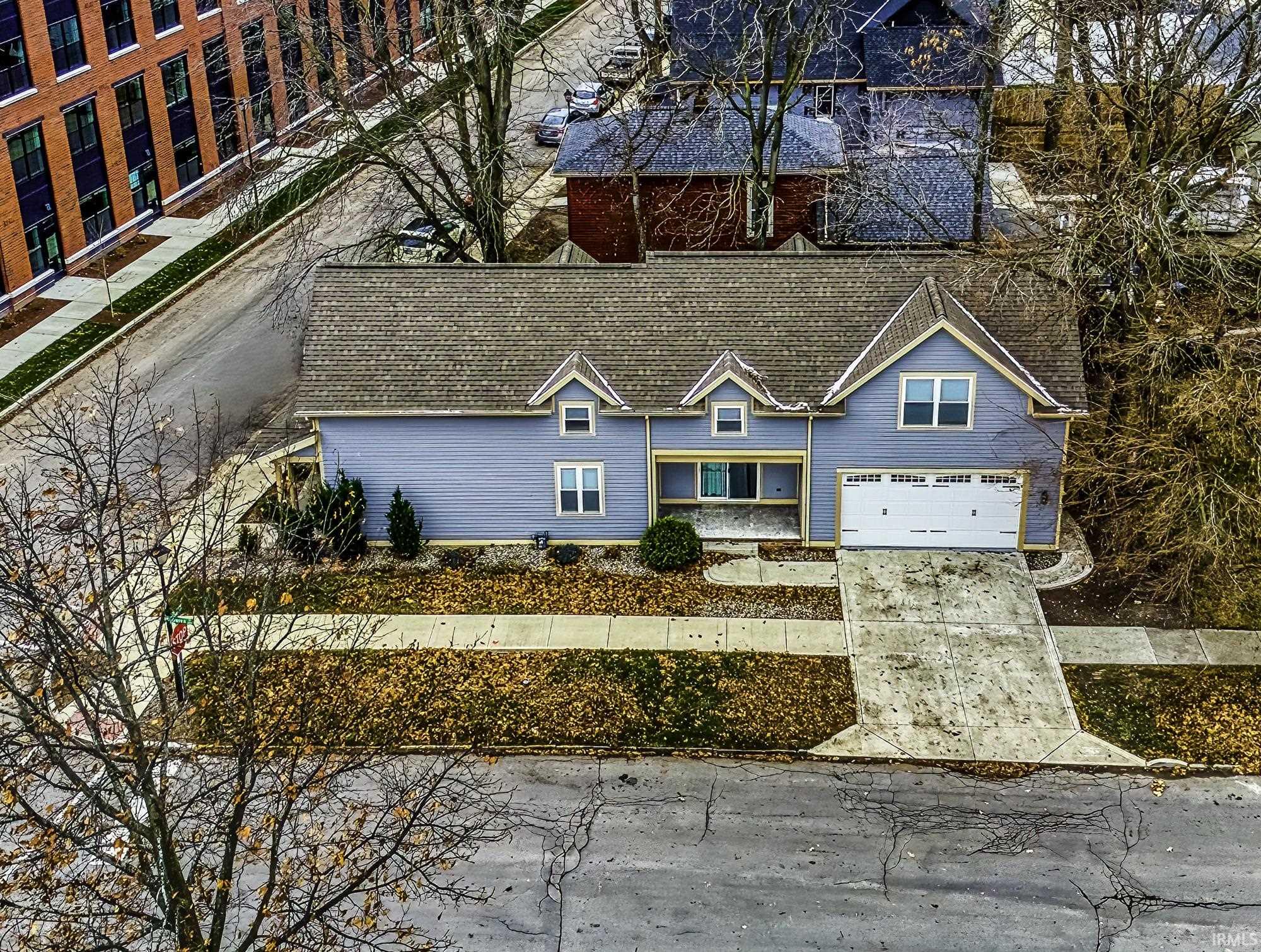 View of front of property featuring concrete driveway and a shingled roof