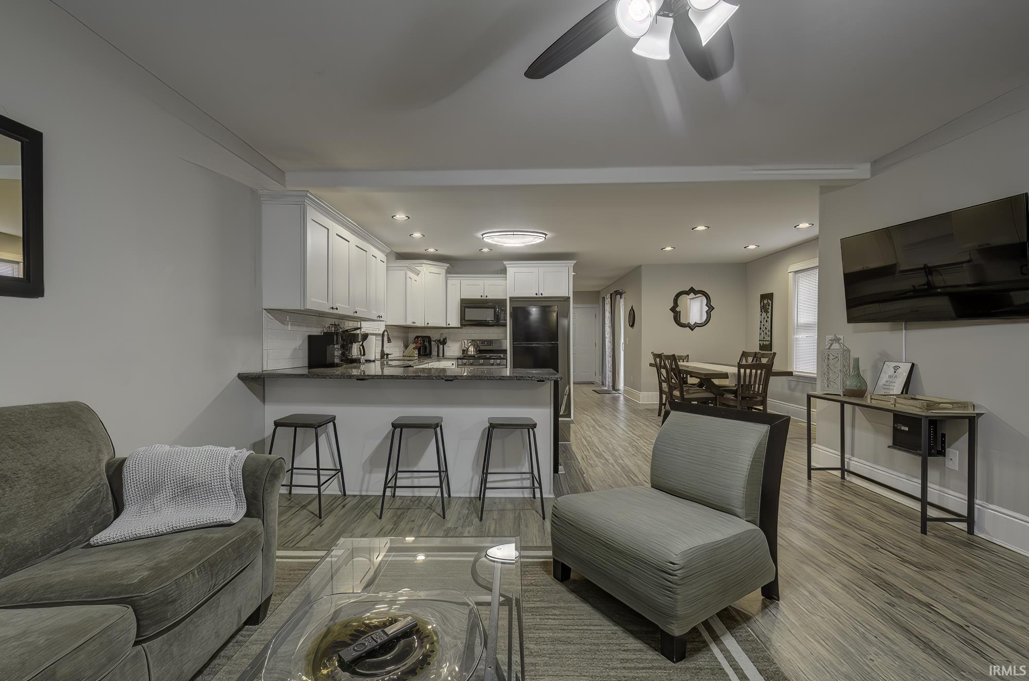 Living area featuring light wood-type flooring, recessed lighting, and a ceiling fan