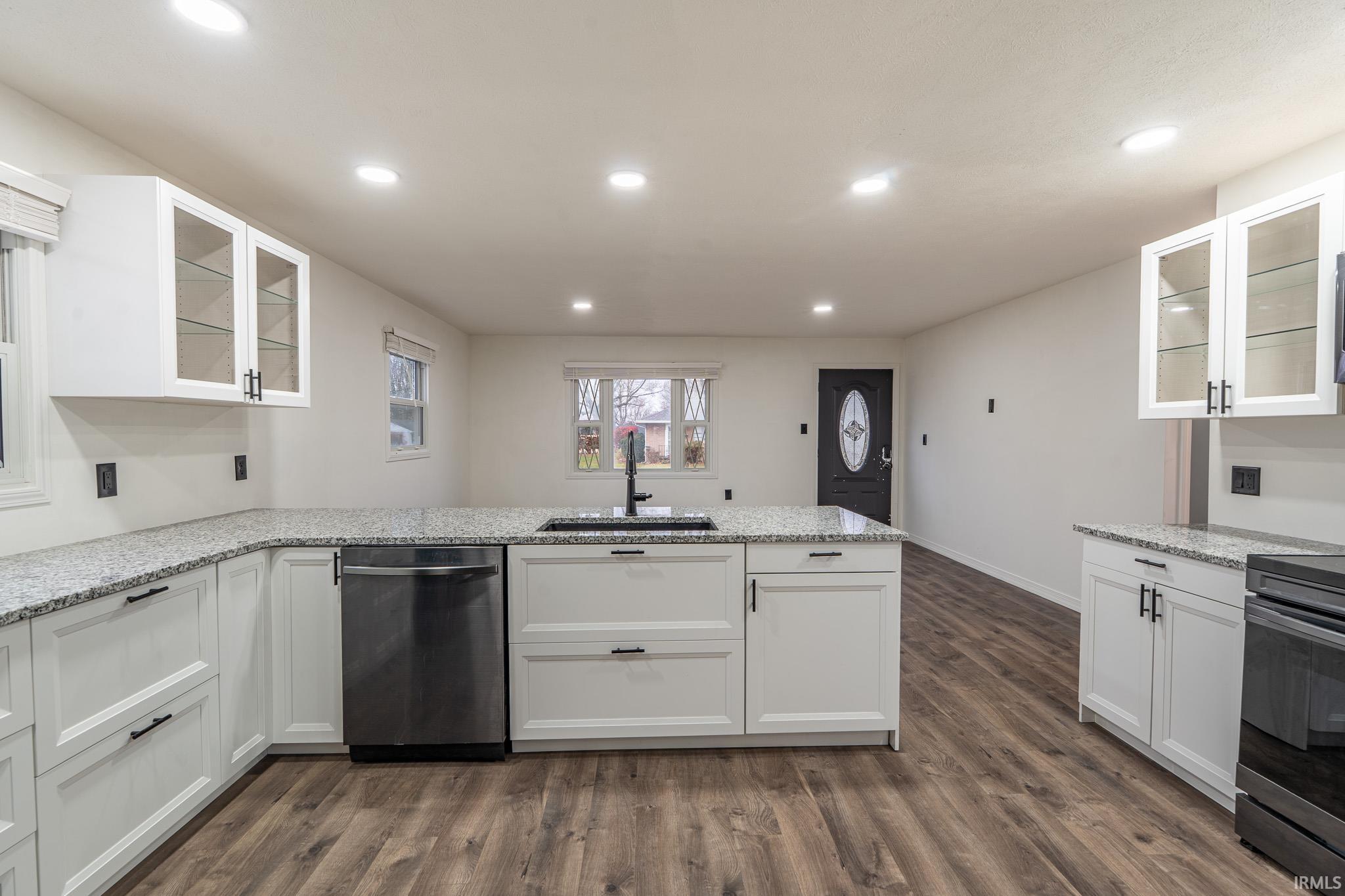 Kitchen featuring glass insert cabinets, white cabinets, and recessed lighting