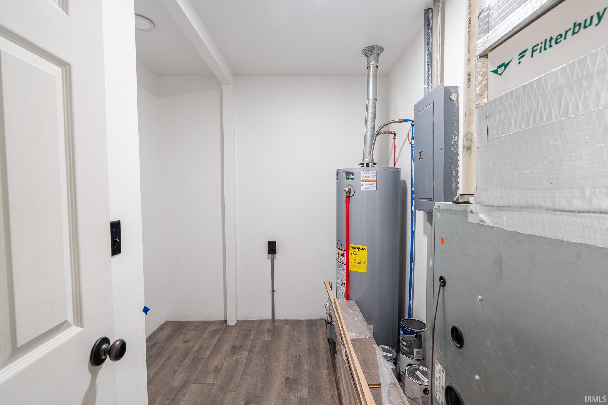 Utilities featuring electric panel, heating unit, and water heater