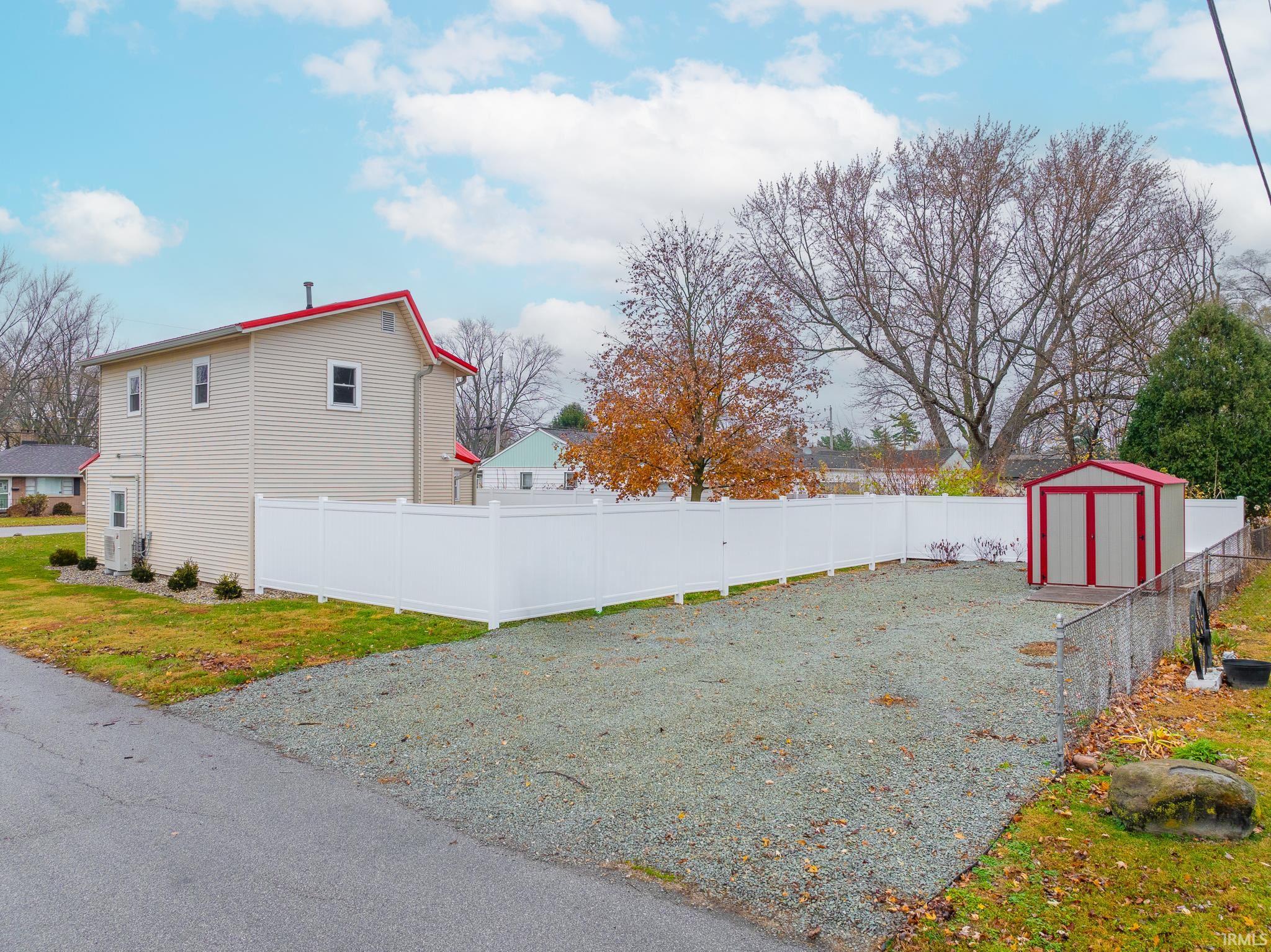 View of property exterior with a fenced backyard and a shed