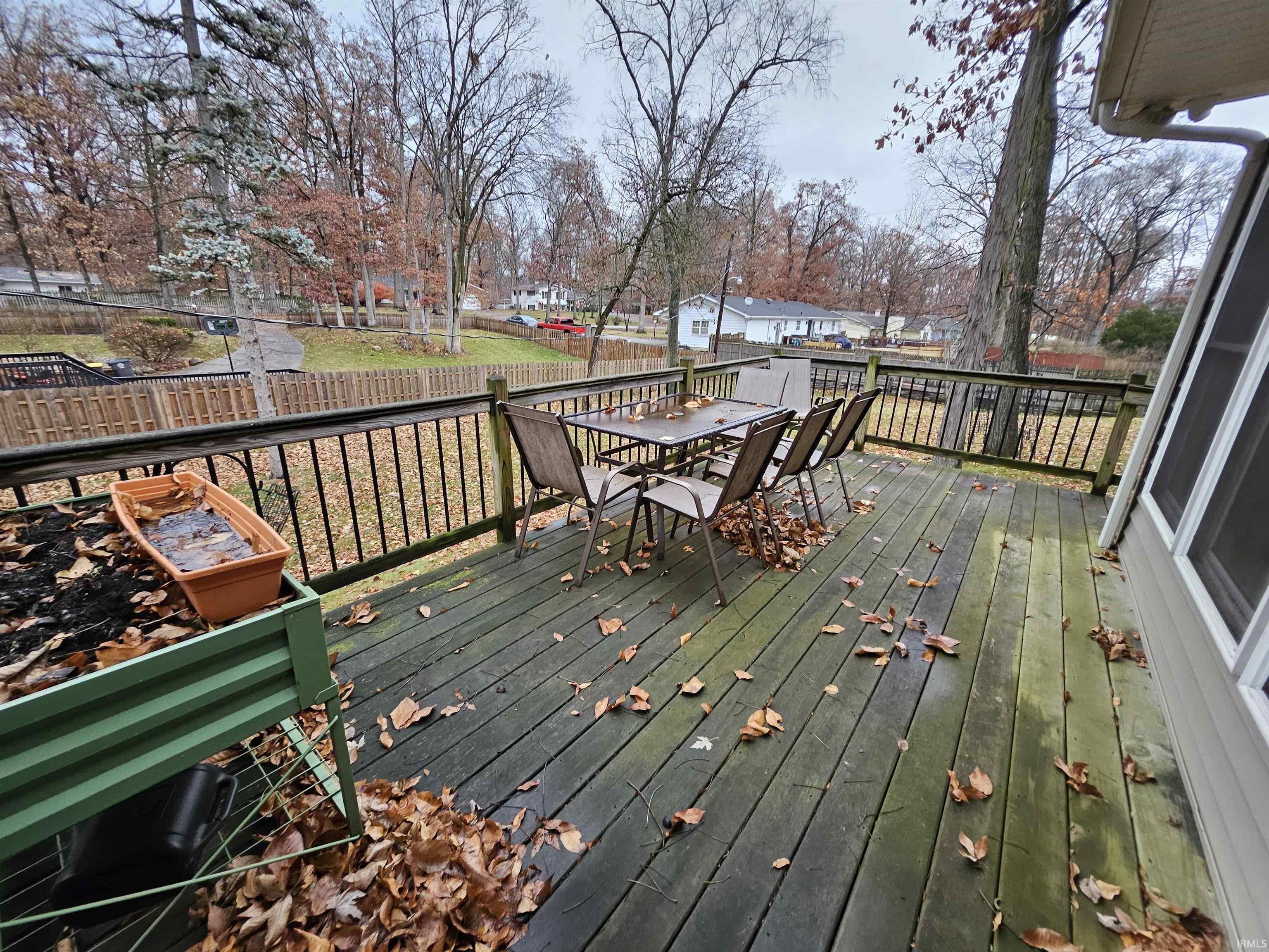 Deck with outdoor dining area, a fenced backyard, and a residential view