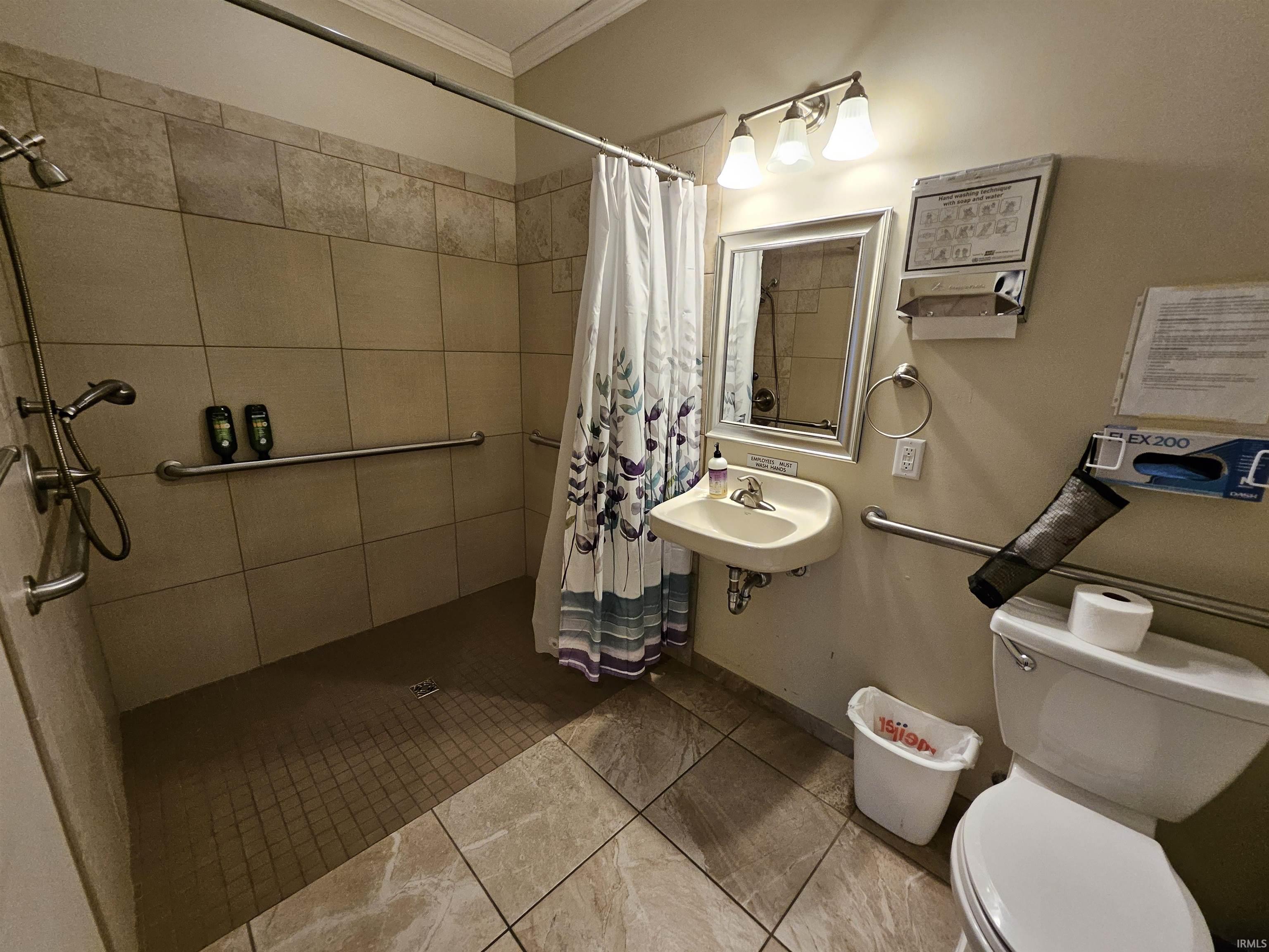 Bathroom featuring crown molding and a tile shower