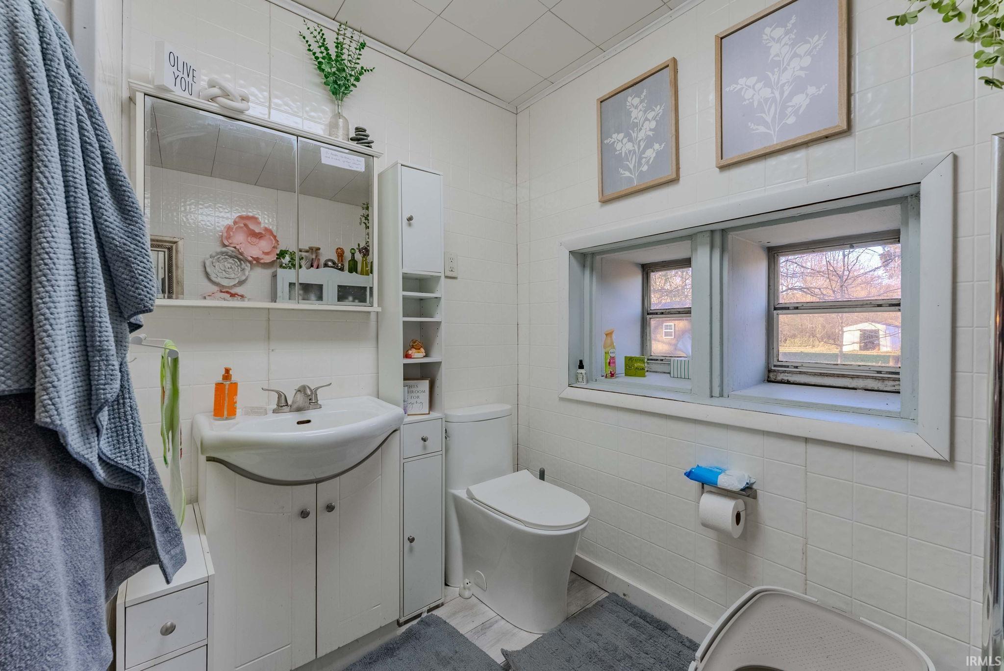 Full bath with tile walls and vanity