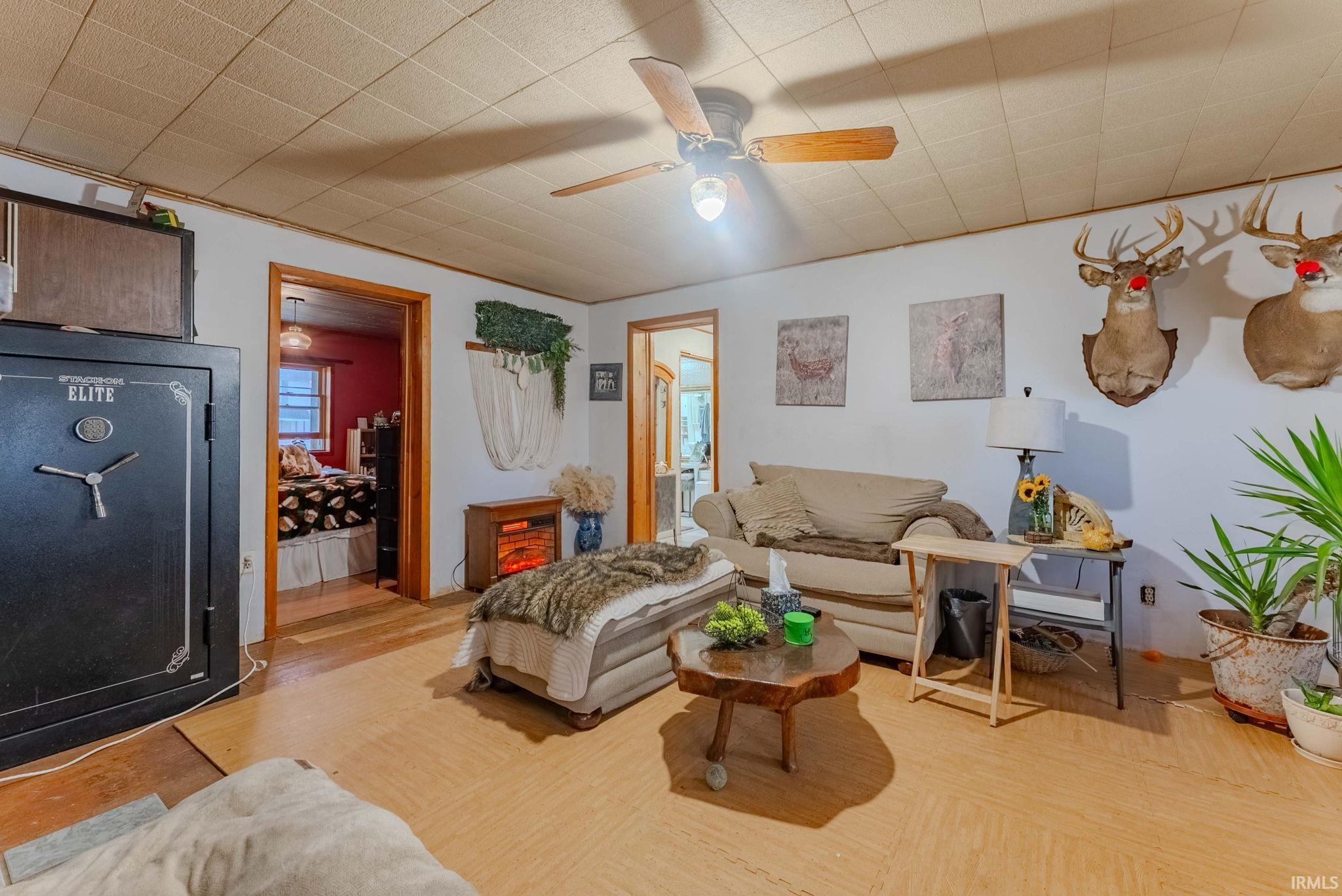 Living area featuring a ceiling fan, healthy amount of natural light, and wood finished floors