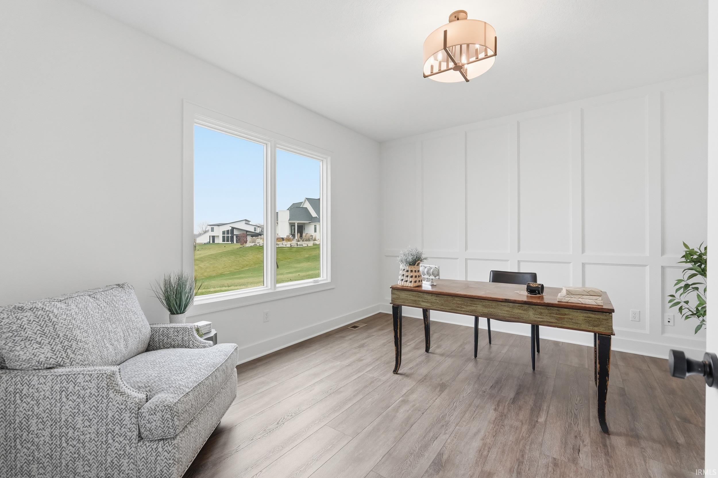 Home office with a decorative wall and wood finished floors