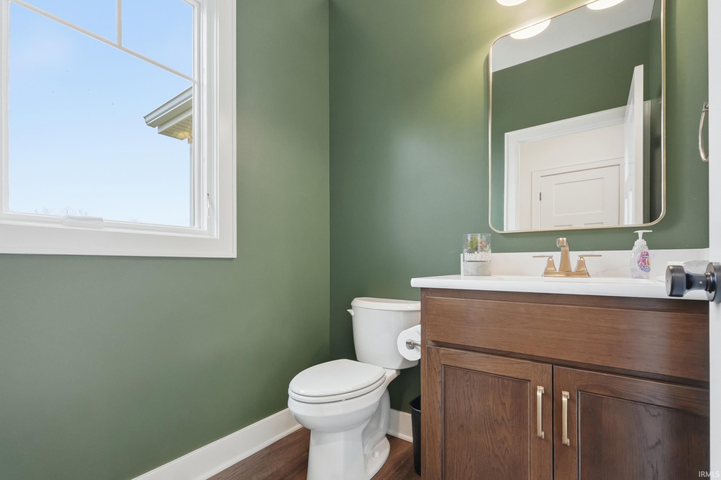 Half bath featuring vanity and dark wood-style flooring