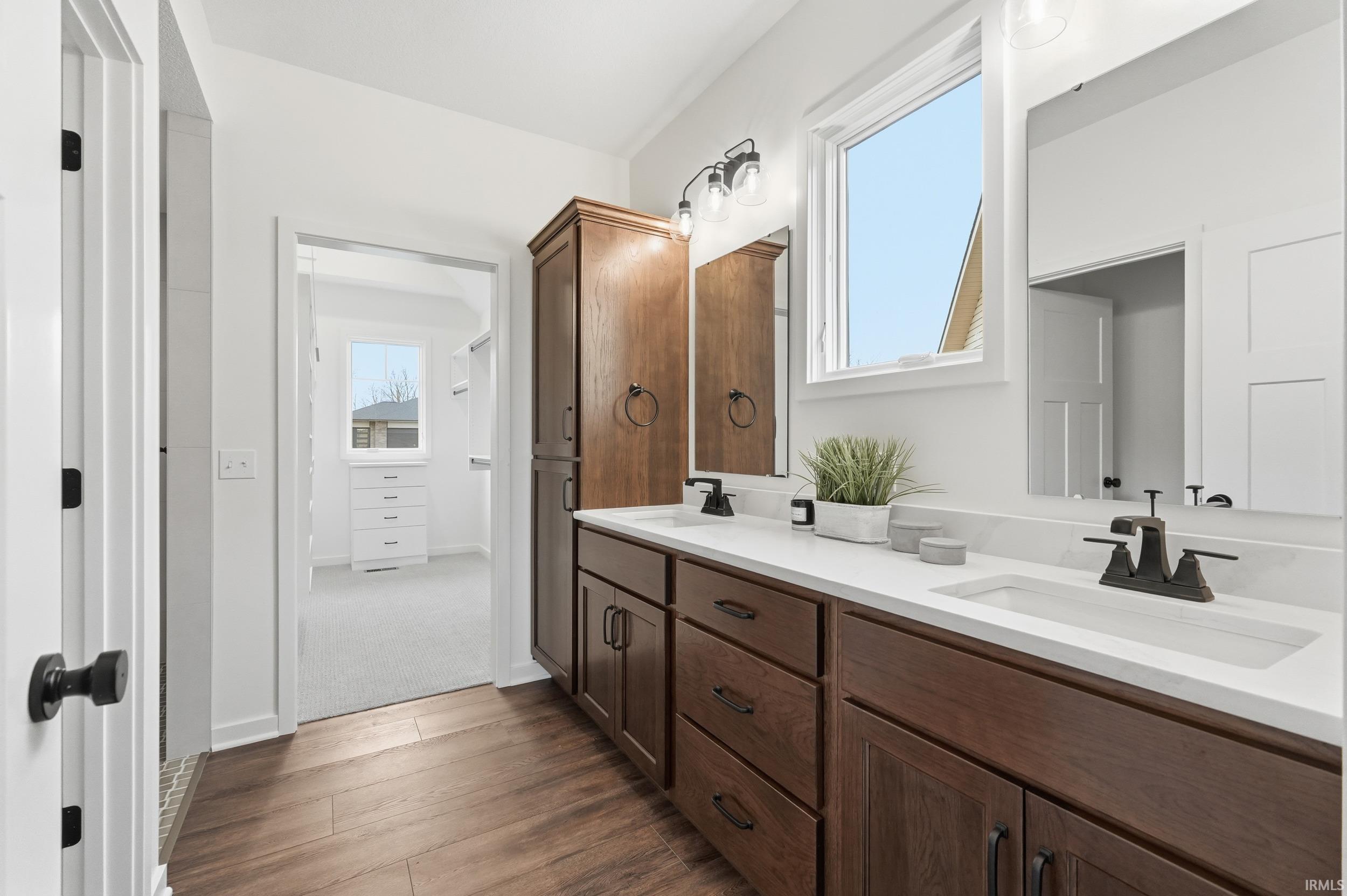 Bathroom with double vanity and dark wood finished floors