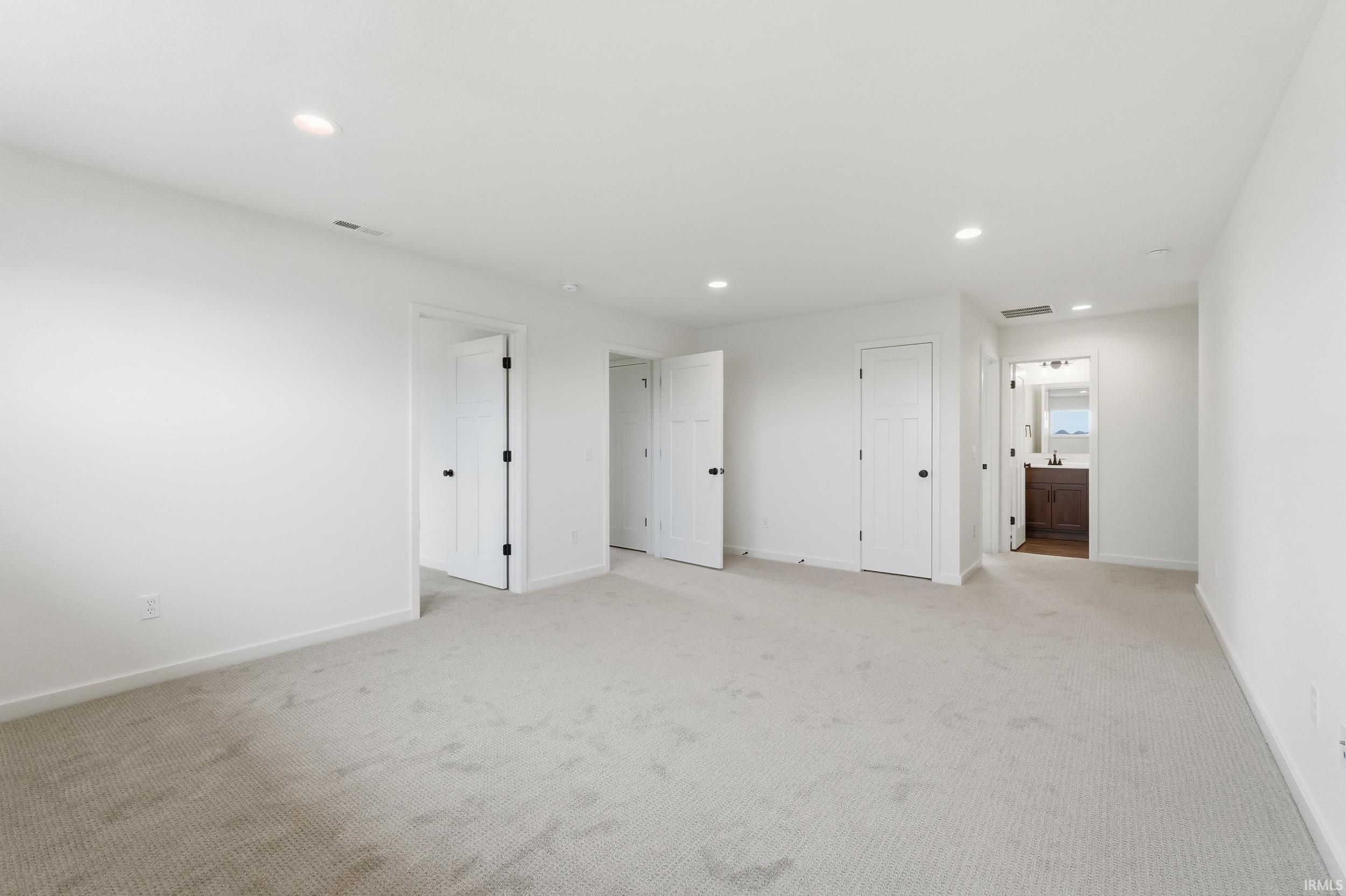 Unfurnished bedroom featuring recessed lighting, carpet, and ensuite bath