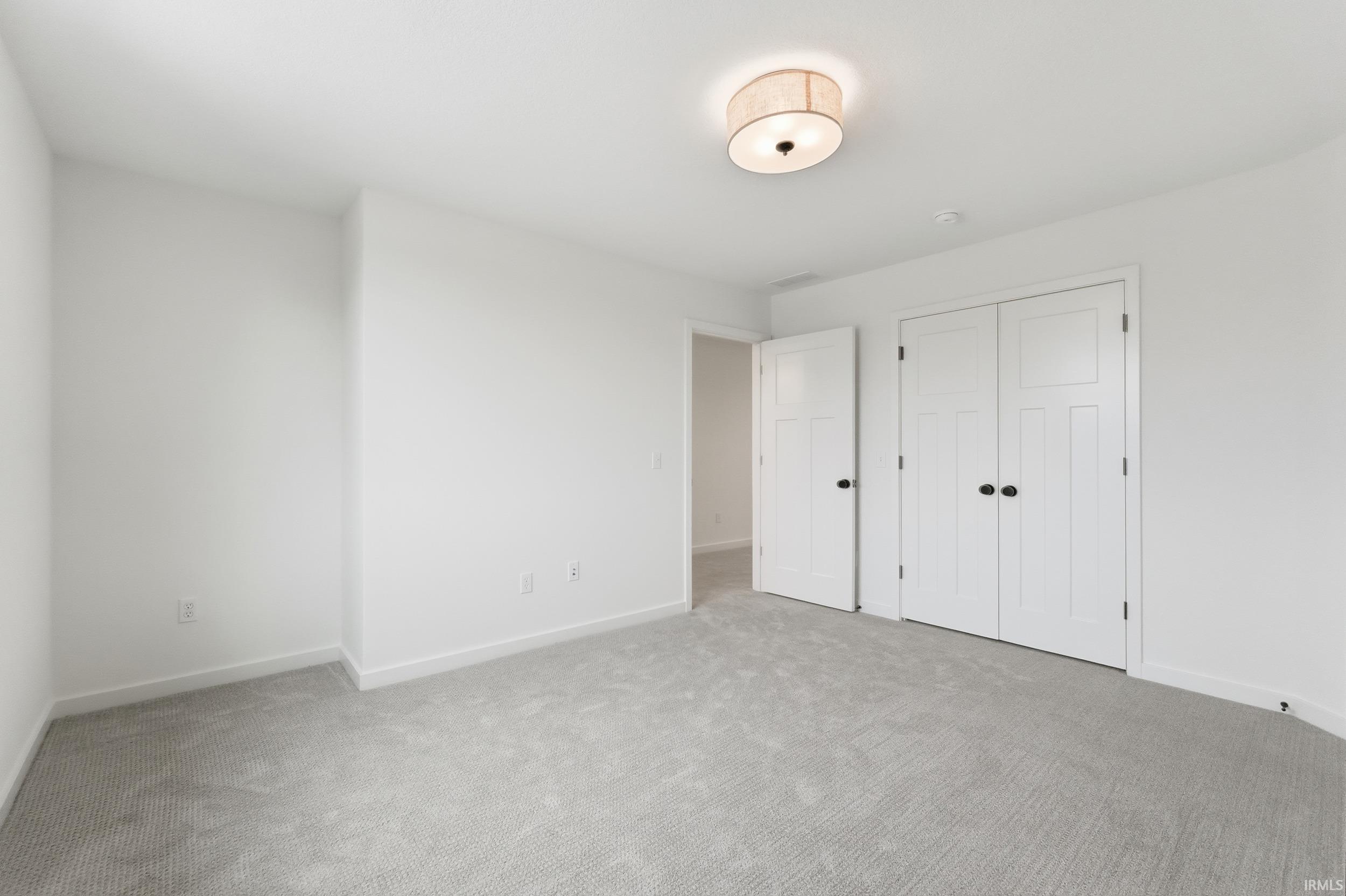 Unfurnished bedroom featuring carpet flooring and a closet