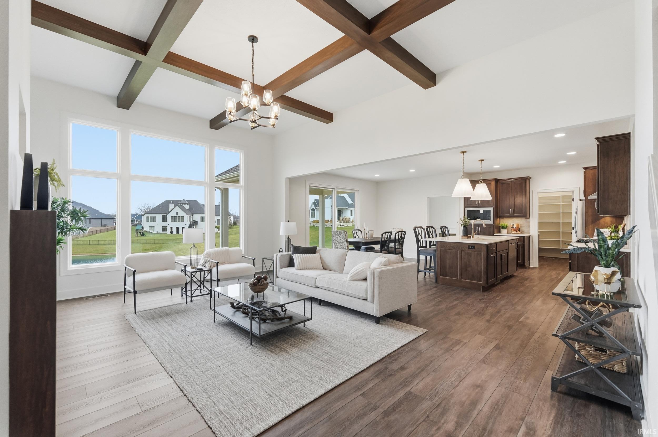 Living area featuring beam ceiling, coffered ceiling, dark wood-type flooring, recessed lighting, and a chandelier