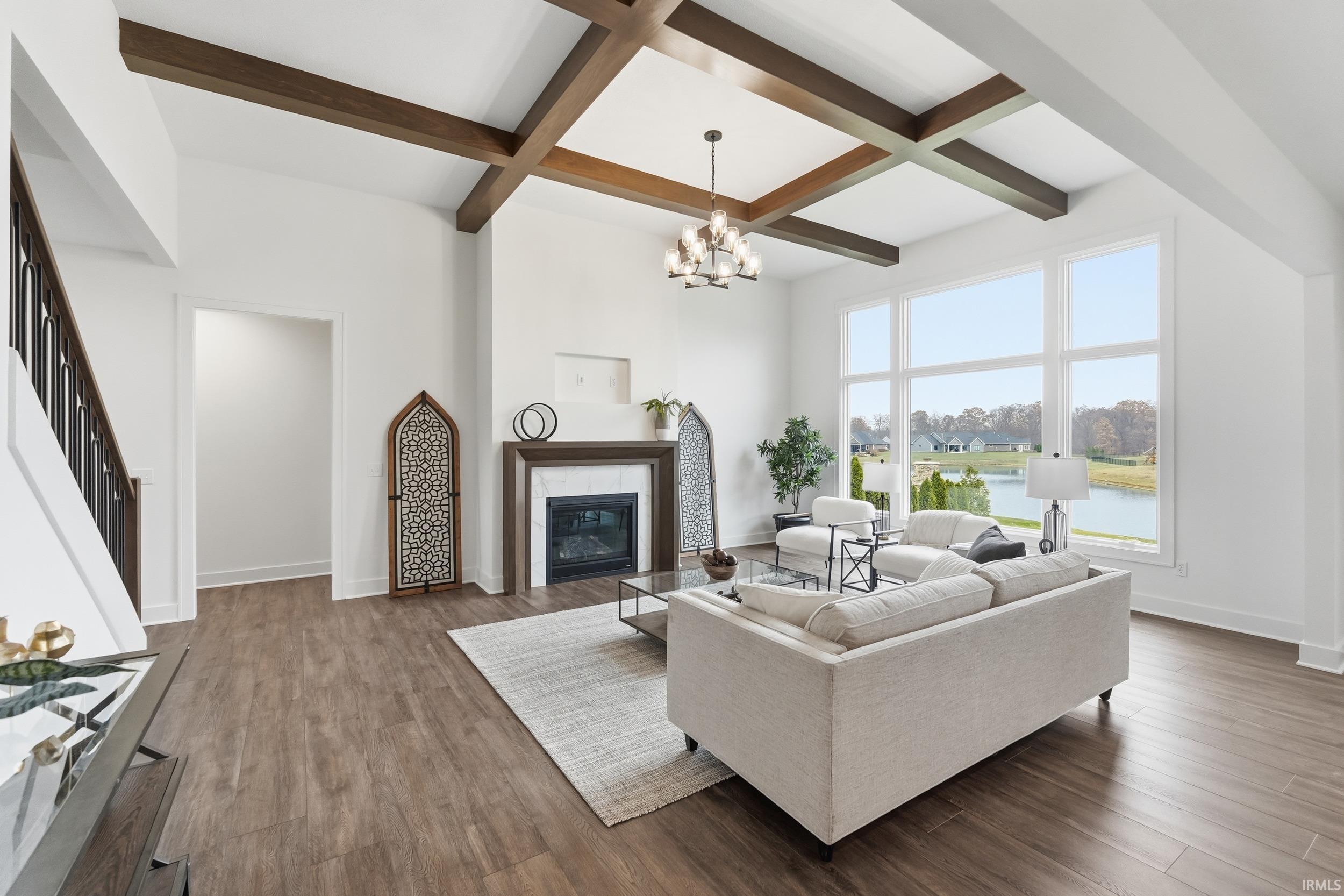 Living room with stairway, coffered ceiling, beamed ceiling, a tile fireplace, and wood finished floors