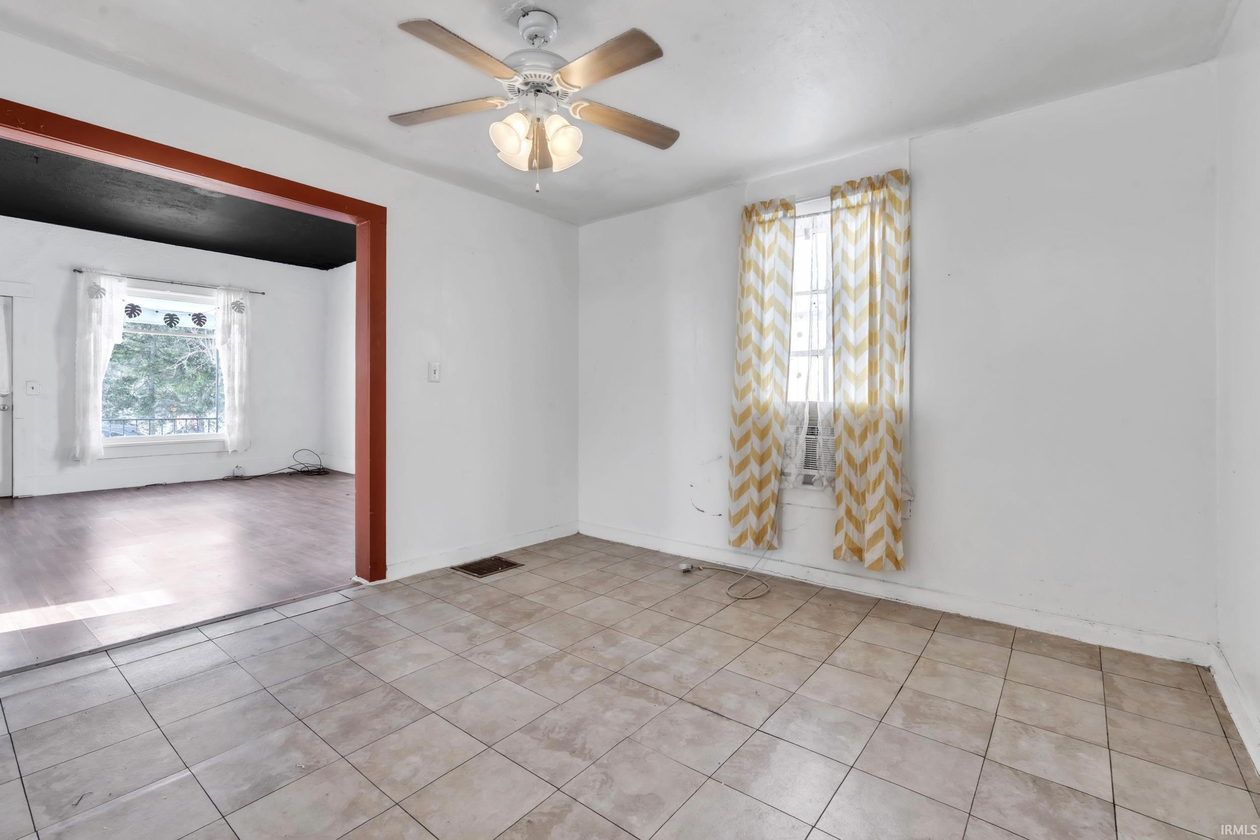Empty room featuring plenty of natural light and a ceiling fan