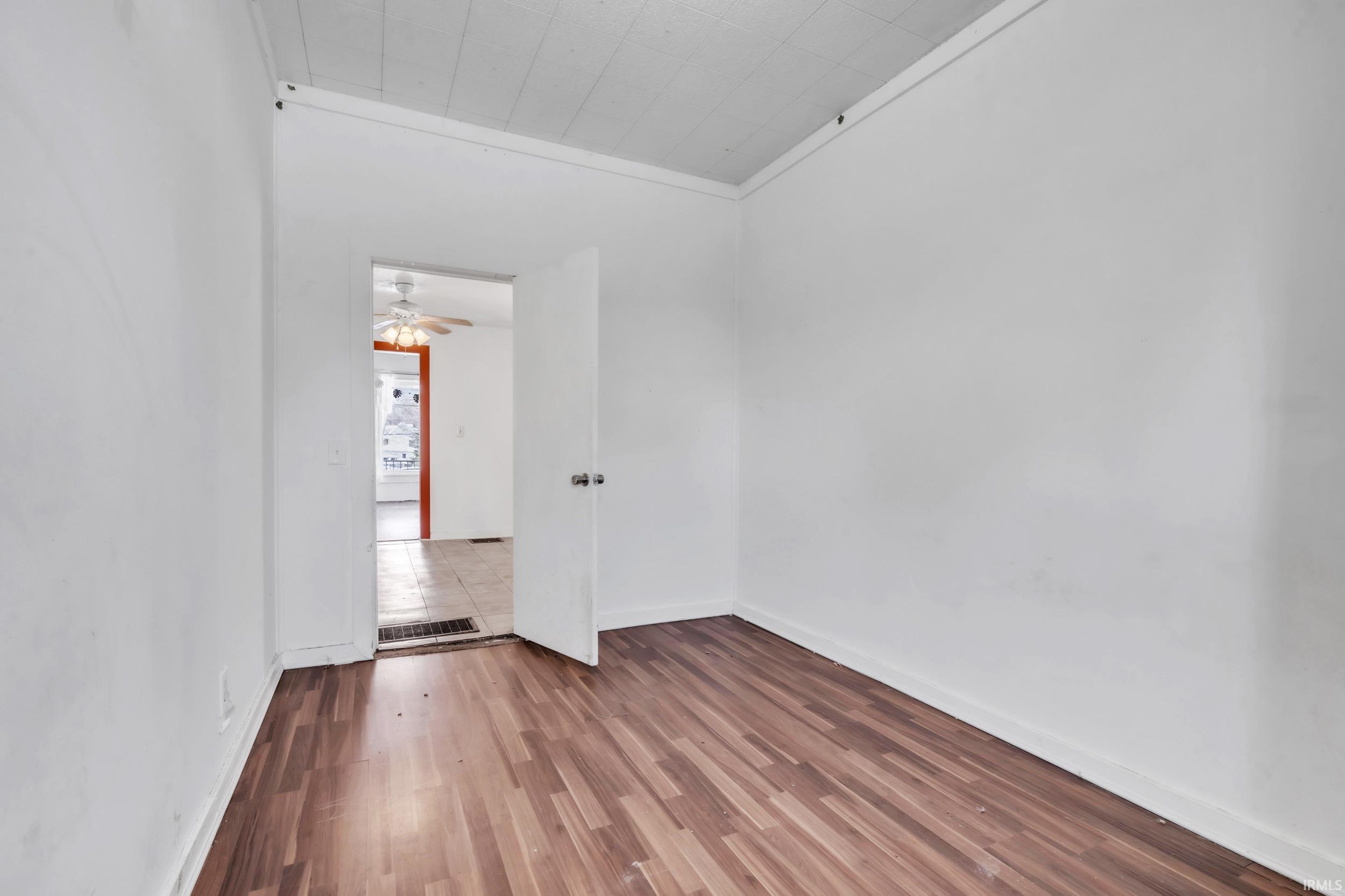 Unfurnished room with wood finished floors and crown molding