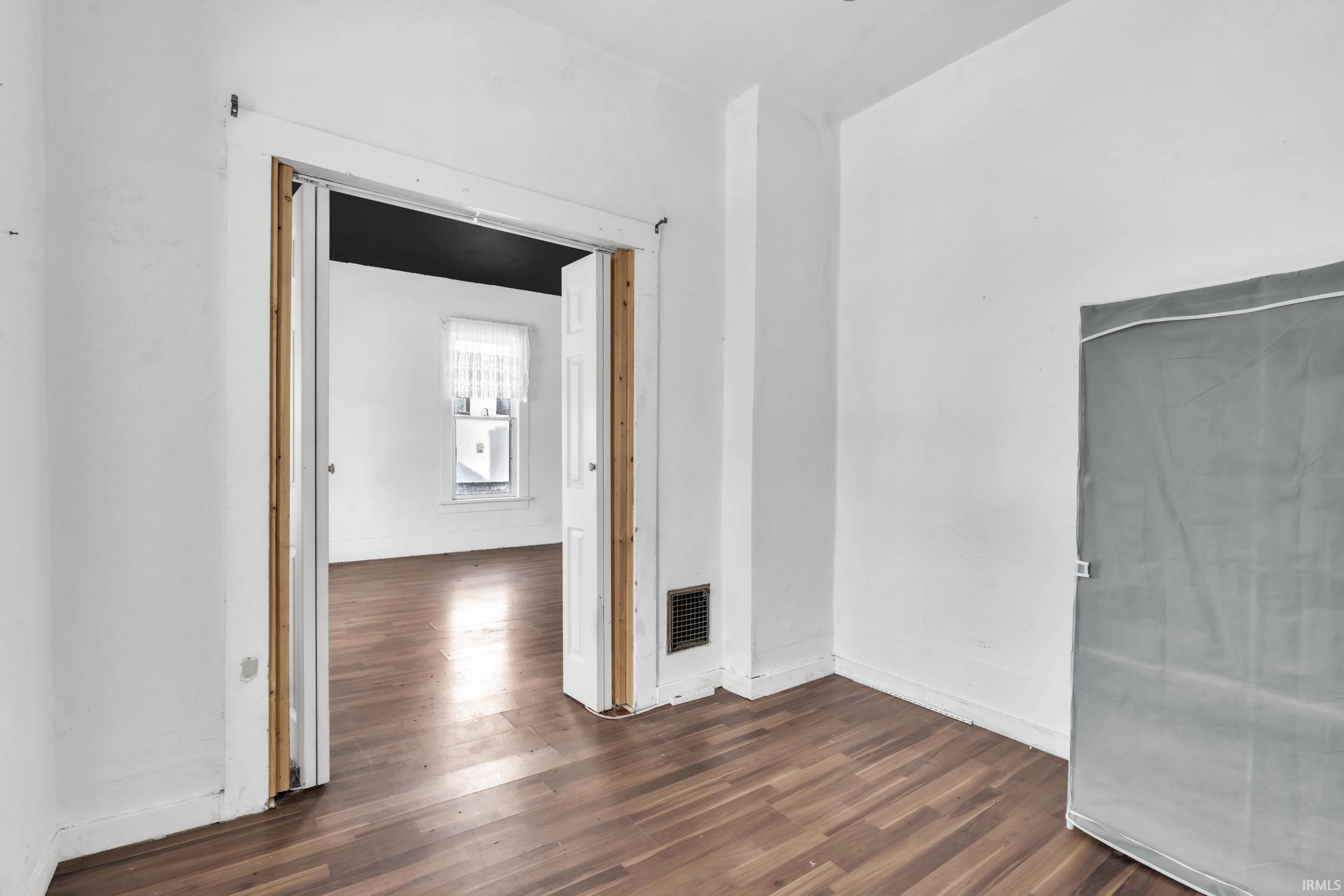 Unfurnished room with dark wood-style floors and baseboards