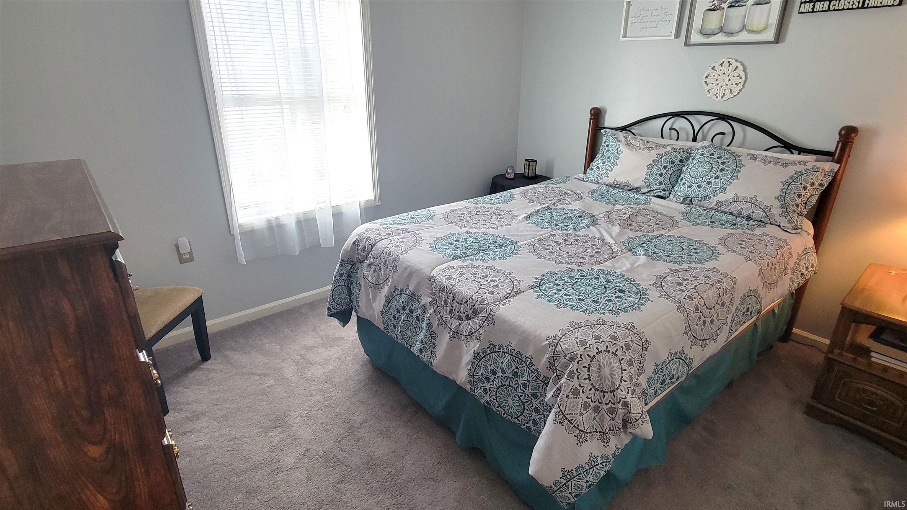 Bedroom featuring carpet flooring and baseboards