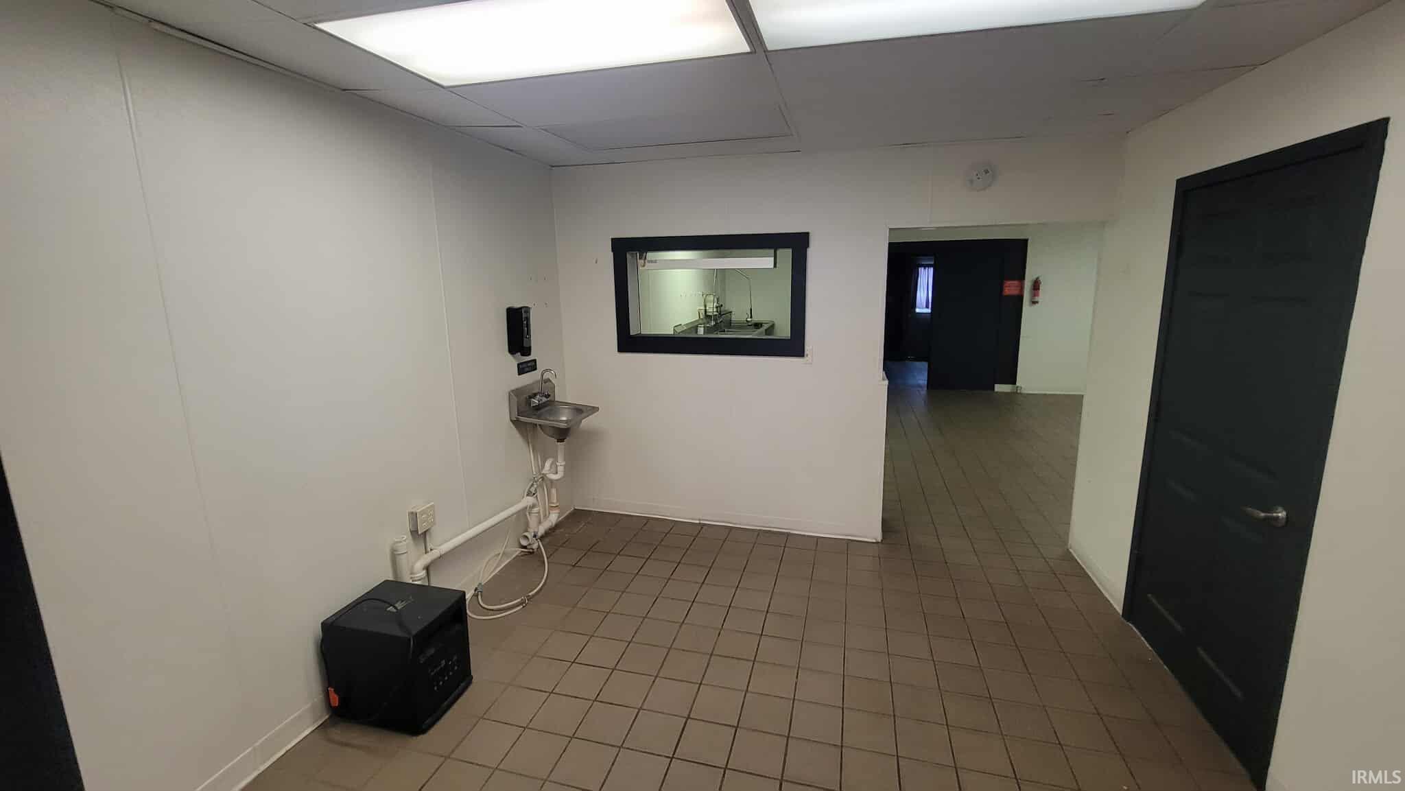 Corridor featuring tile patterned flooring and a paneled ceiling