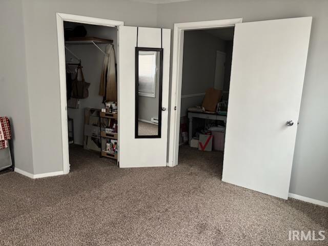 Carpeted bedroom with a spacious closet and baseboards