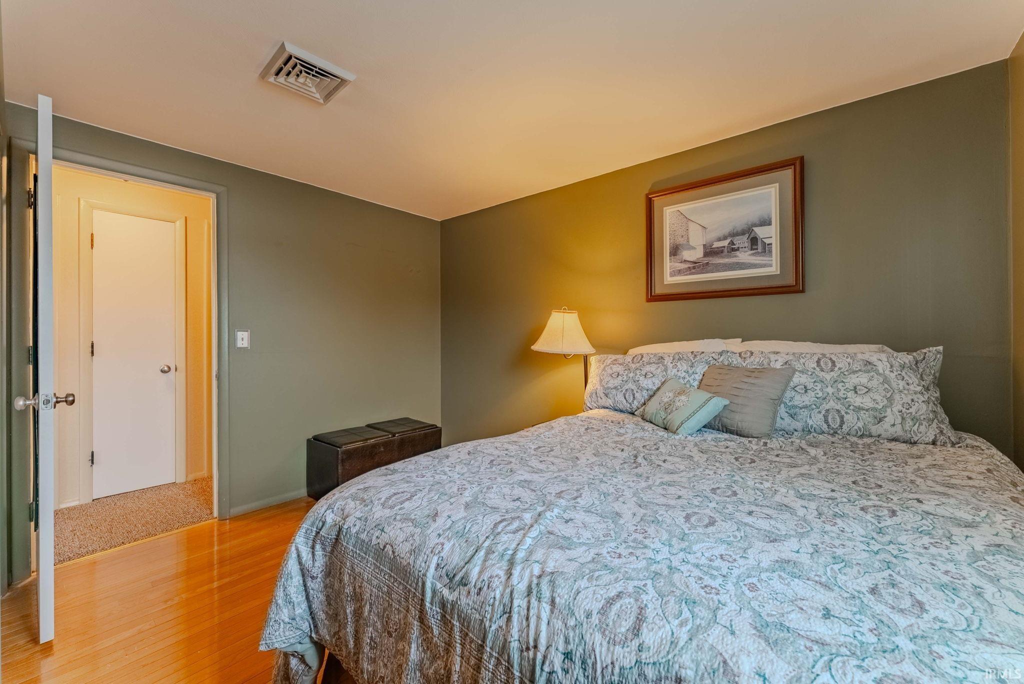Bedroom with wood-type flooring and baseboards