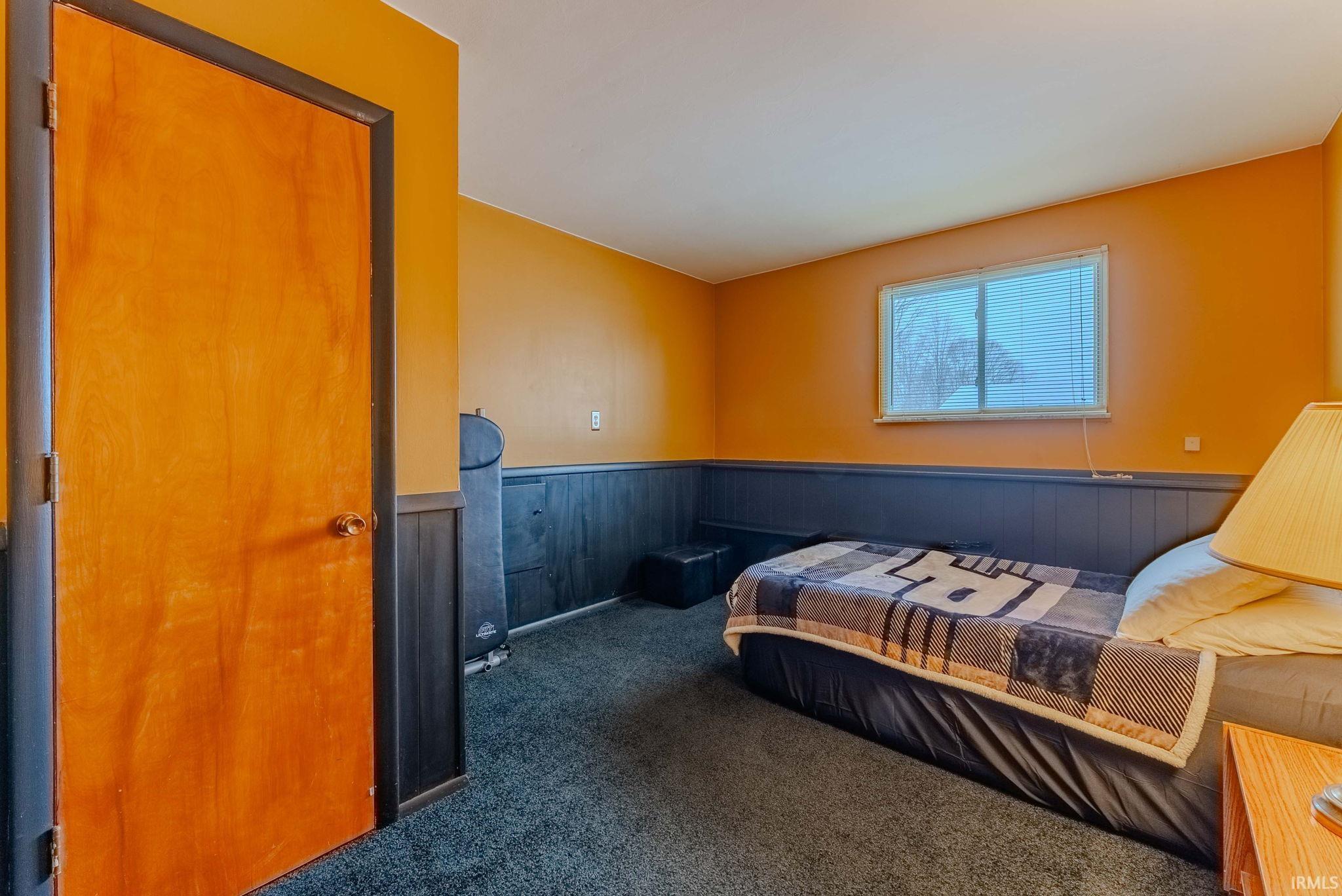 Bedroom featuring wainscoting and carpet floors
