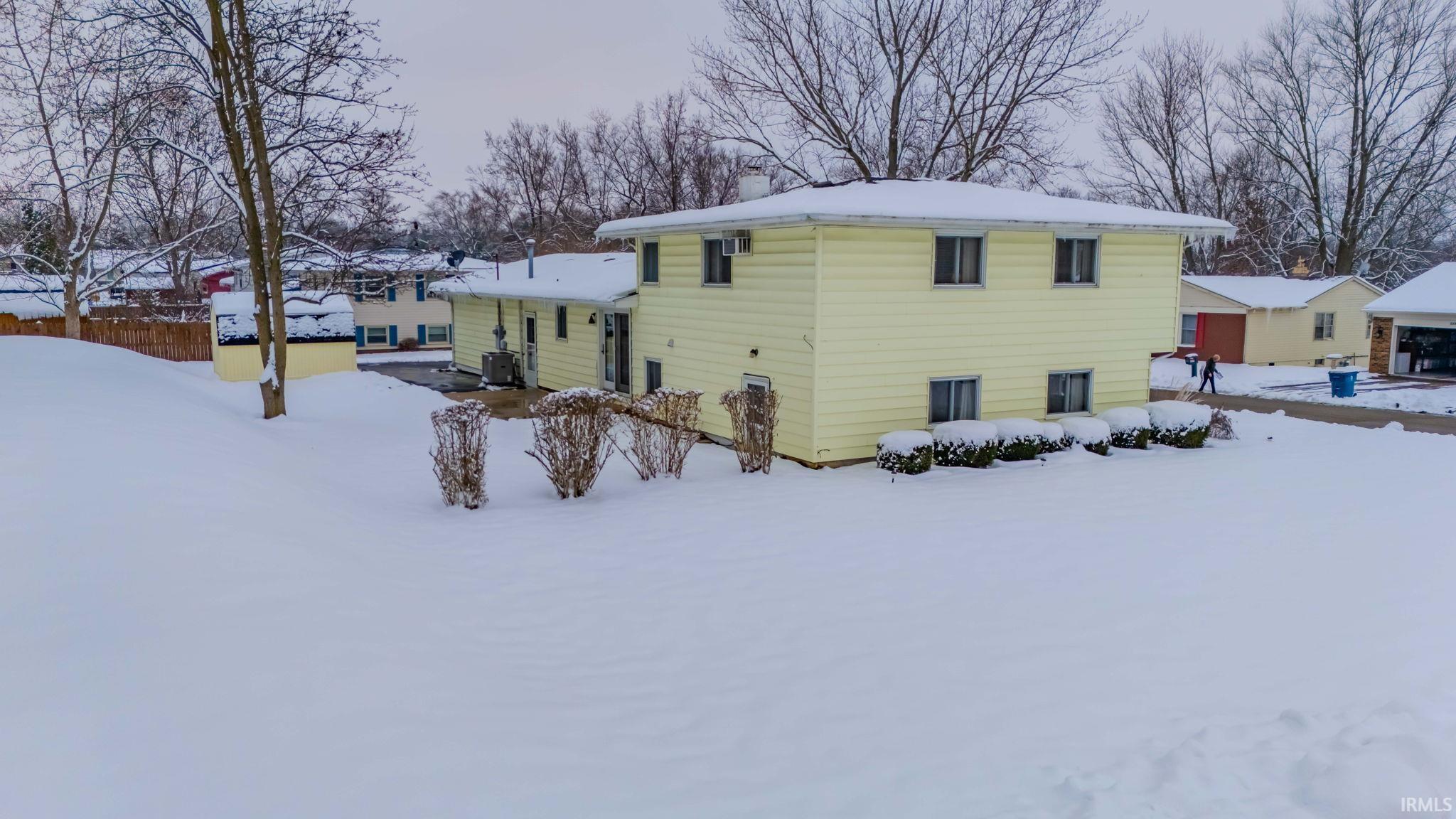 View of snow covered exterior featuring a chimney
