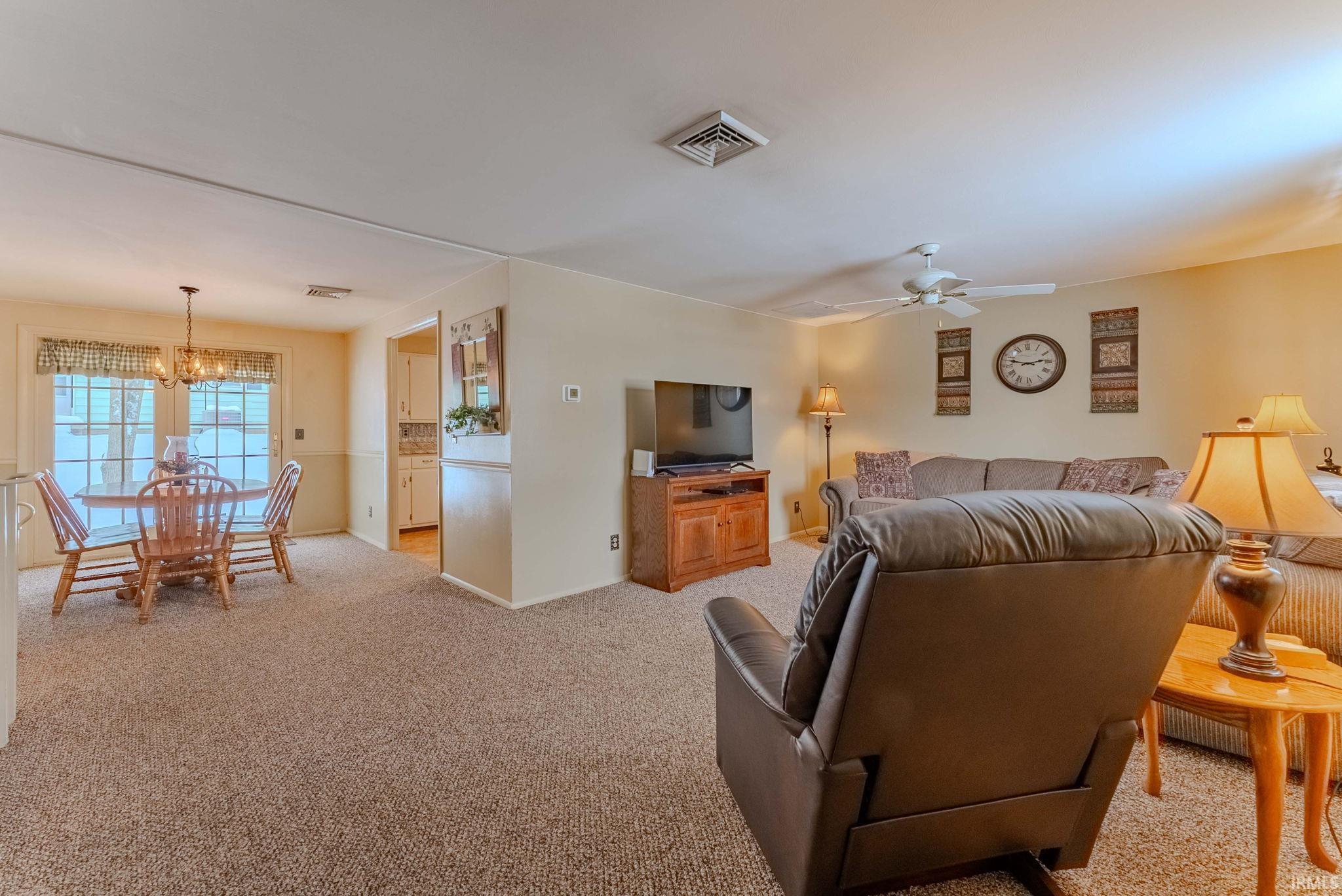Living area with light colored carpet and a chandelier